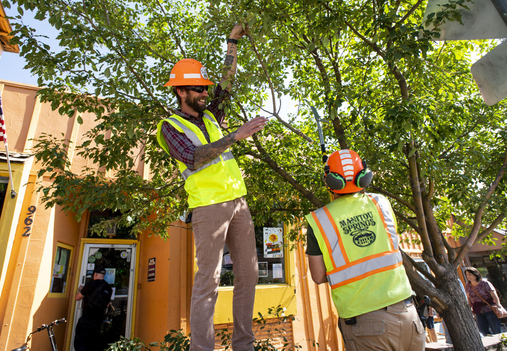 Manitou Springs City Maintenance worker Justin Weber, left, helps City Arborist Matthew Nelson trim a tree to make way for a new seven-foot-tall guitar statue on Manitou Avenue on Friday, Sept. 9, 2022. (The Gazette, Parker Seibold) (Parker Seibold/ The Gazette)
