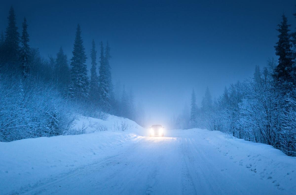 lights of car and winter road in forest Photo Credit: IakovKalinin (iStock).