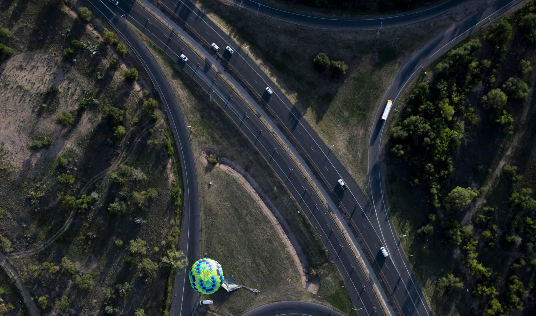A hot air balloon lands on the edge of a grassy patch between a series of roads on Friday, Sept. 2, 2022. (The Gazette, Parker Seibold) (The Gazetter Parker Seibold)