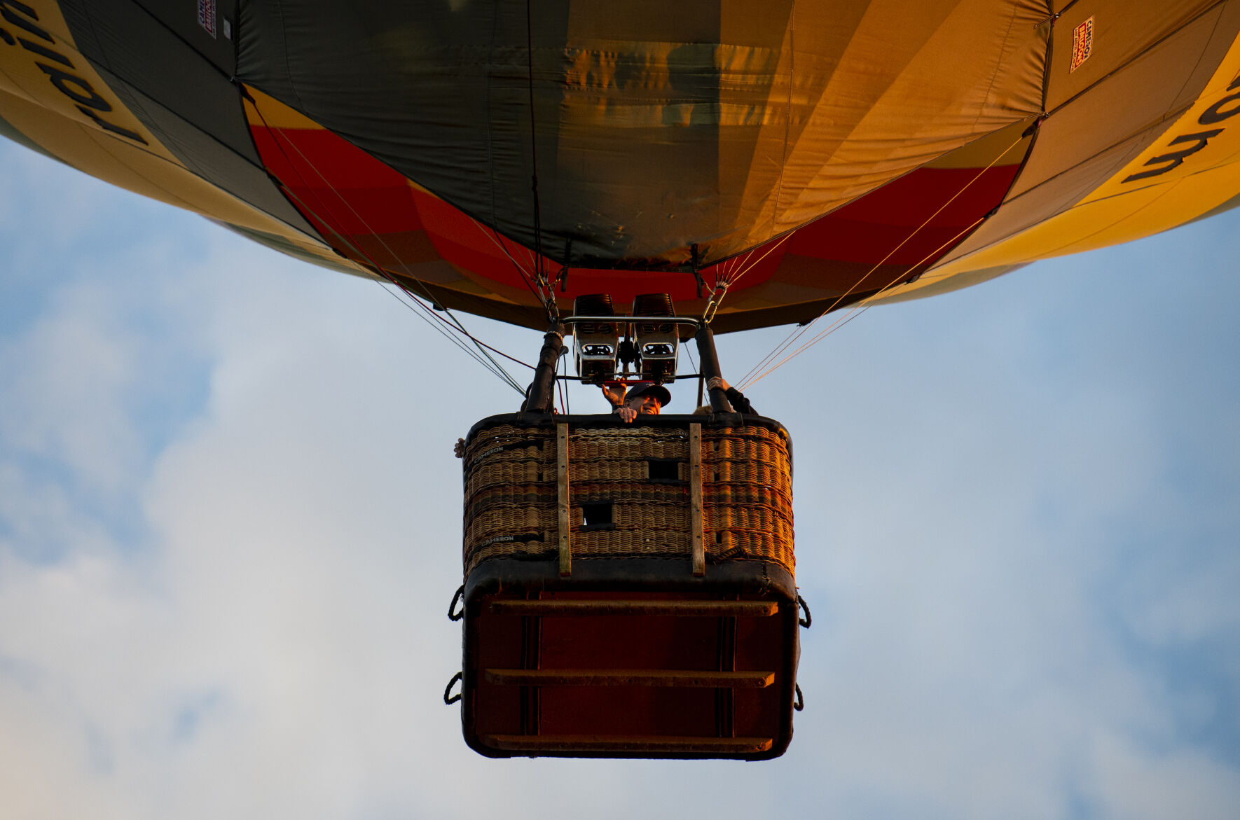 A person looks over the edge of a basket of a hot air balloon on Friday, Sept. 2, 2022. (The Gazette, Parker Seibold) (The Gazetter Parker Seibold)