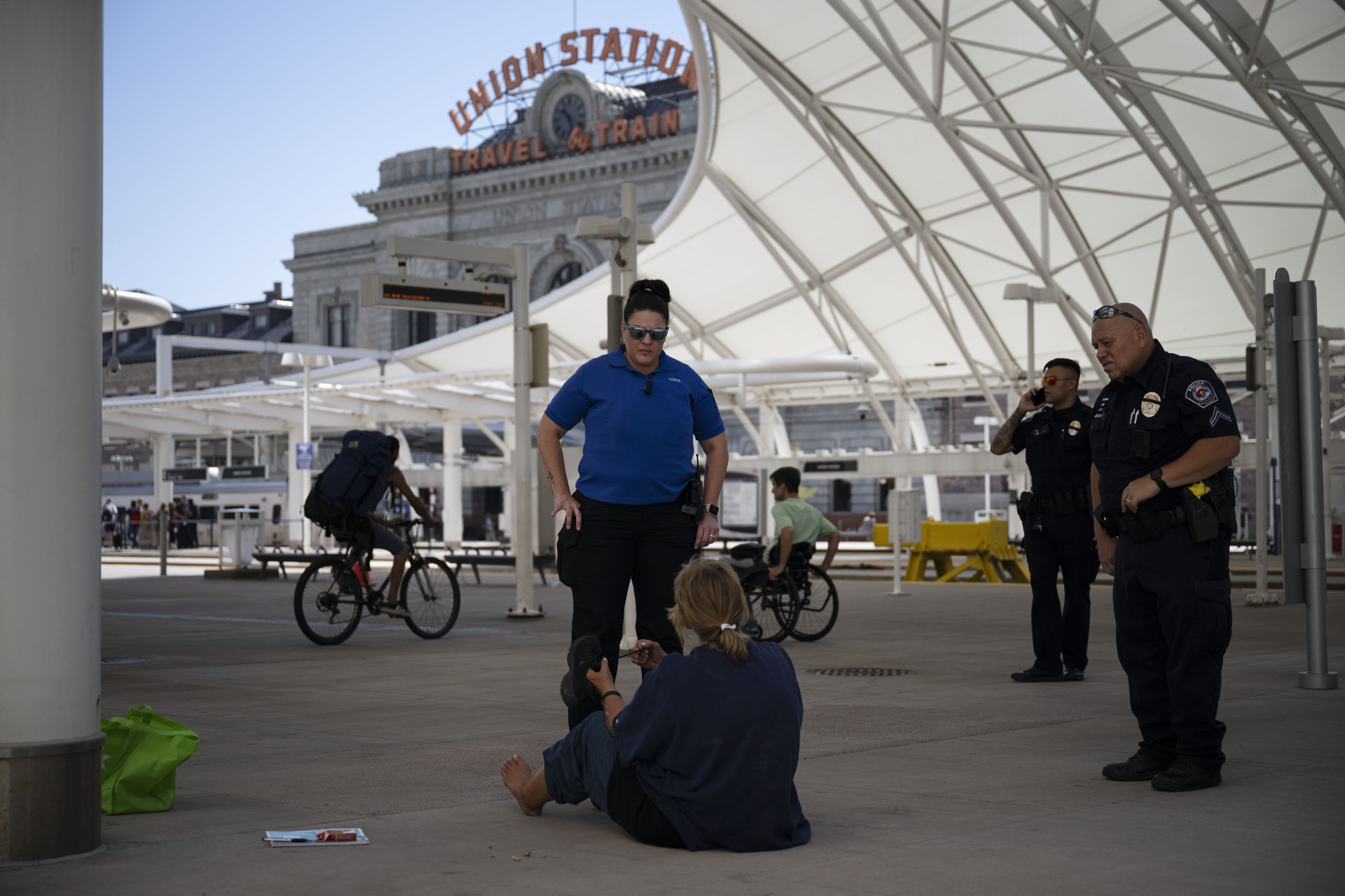 Mental health clinician co-responder Leanne Figueroa, left, and RTD Police Cpl. Conrad Vanegas conduct a welfare check on a woman who was seen lying down on the outdoor commuter rail concourse, resulting in a visit from an EMS crew on Thursday, Aug. 11, 2022, at Union Station in Denver, Colo. (Timothy Hurst/The Denver Gazette) (Timothy Hurst)