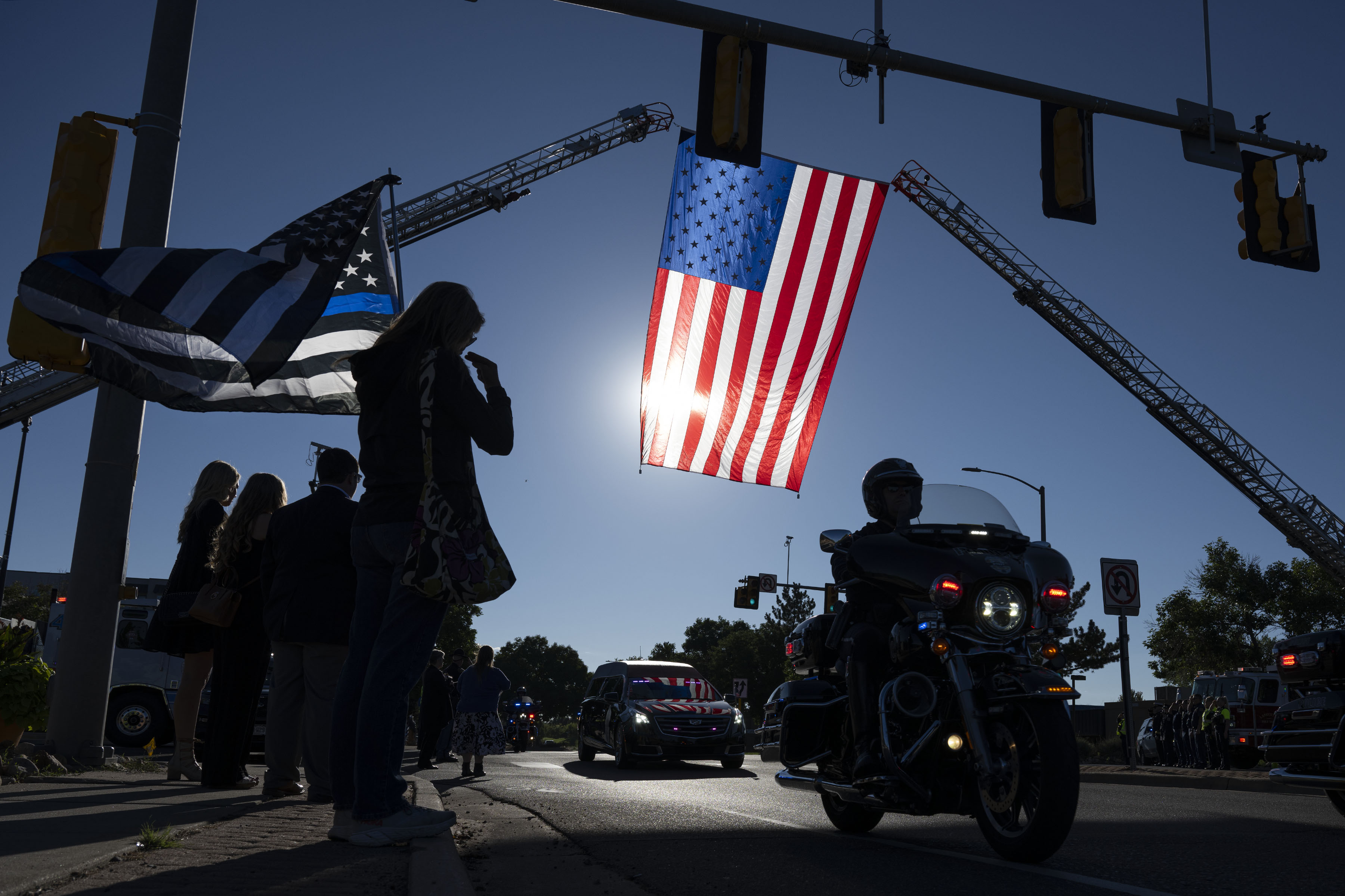 A mourner does the sign of the cross while holding a thin blue line American flag during a the funeral procession for fallen Arvada Police officer Dillon Vakoff on Friday, Sept. 16, 2022, at Flatirons Community Church in Lafayette, Colo. Vakoff was killed in the line of duty last Sunday while responding to a call in Arvada. (Timothy Hurst/The Denver Gazette) (TimHursttim.hurst@gazette.comhttps://secure.gravatar.com/avatar/aca82bd62b4ee425c598527cd6faa1b1?d=mm&r=g)
