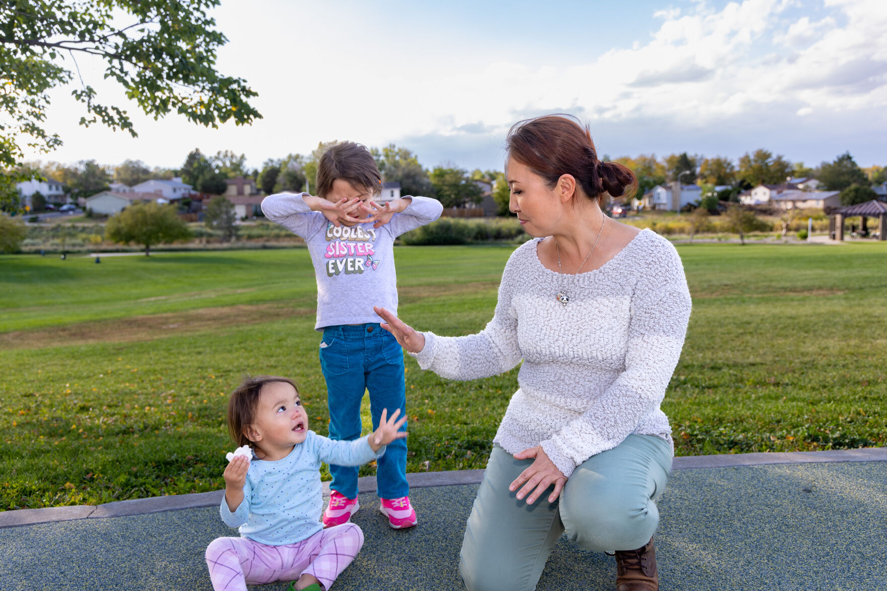 Jing Tesoriero plays with her daughters Chloe, 4, and Tylee Holberger, 2, last week at Highland Hollows Park in Aurora. Her 10-year-old son, Ty, was killed in 2019 by his abusive father after a contentious custody hearing. Jing has been outspoken about what she says was a systemic failure to protect her son from his father. (Liz Copan, special to the gazette)