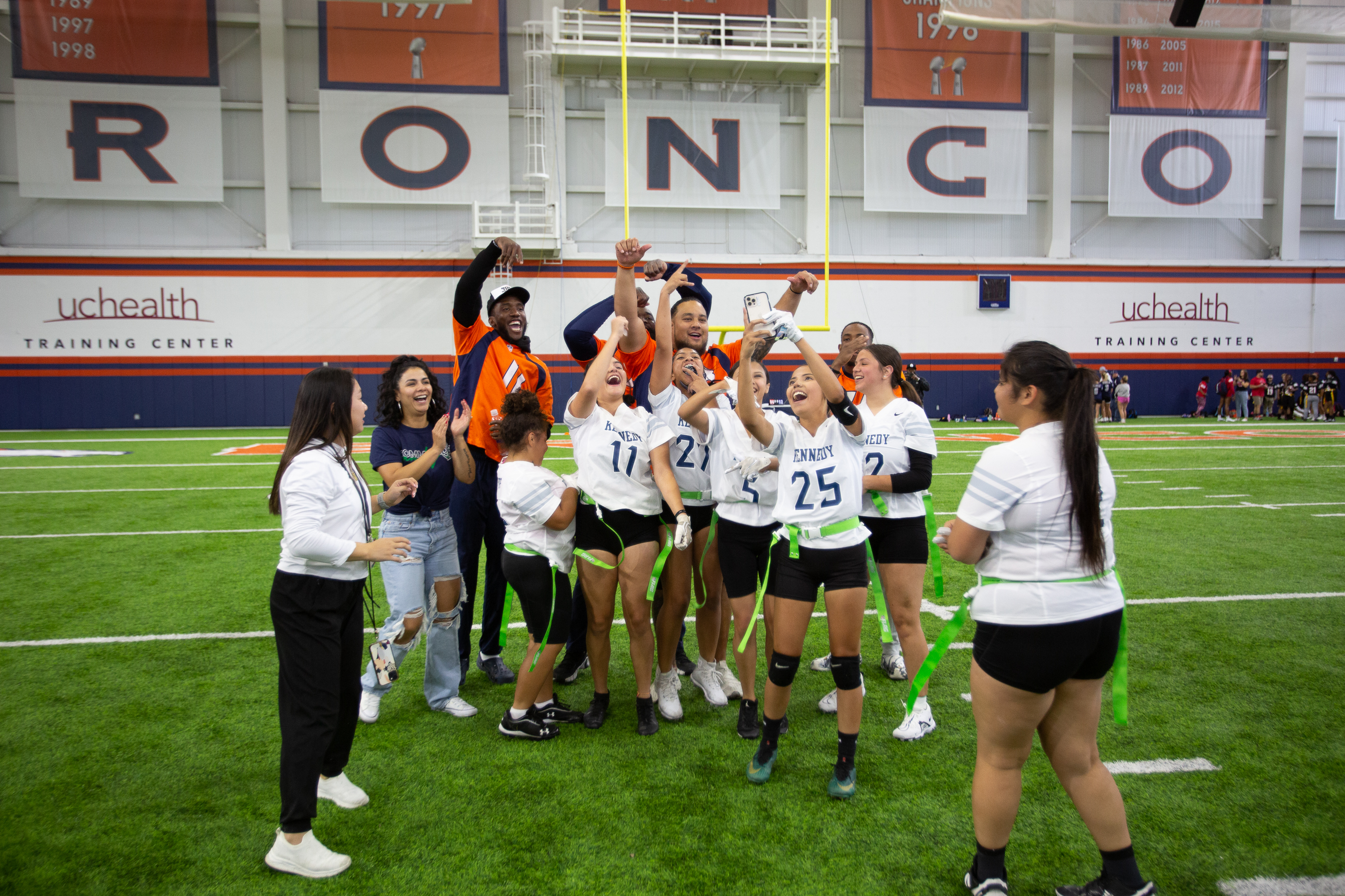 Kennedy High School players join together for a selfie with Broncos players after winning the first game of the Girl's High School Flag football Championship tournament Saturday. (Sara Hertwig/for The Denver Gazette) (Sara Hertwig)