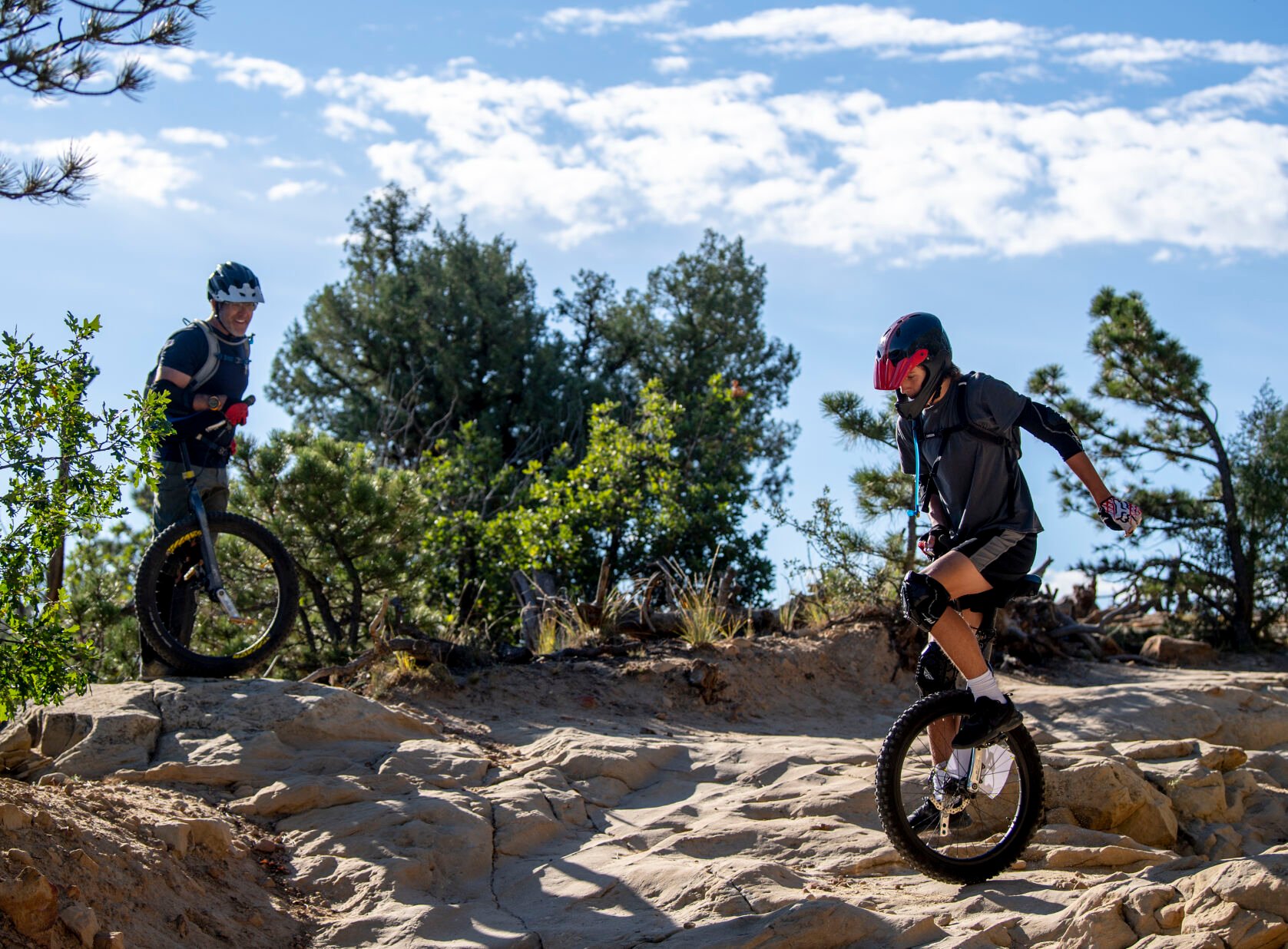 Rob Urban coaches his son, Zane Urban, through a line on his mountain unicycle at Ute Valley Park last week. Mountain unicyclists are a rare breed. “There’s more unicyclists than you think, but as far as people riding on rough terrain, it’s a pretty small universe,” Rob Urban says. And, he adds, “There’s a lot of falling involved.” (Parker Seibold, The Gazette)