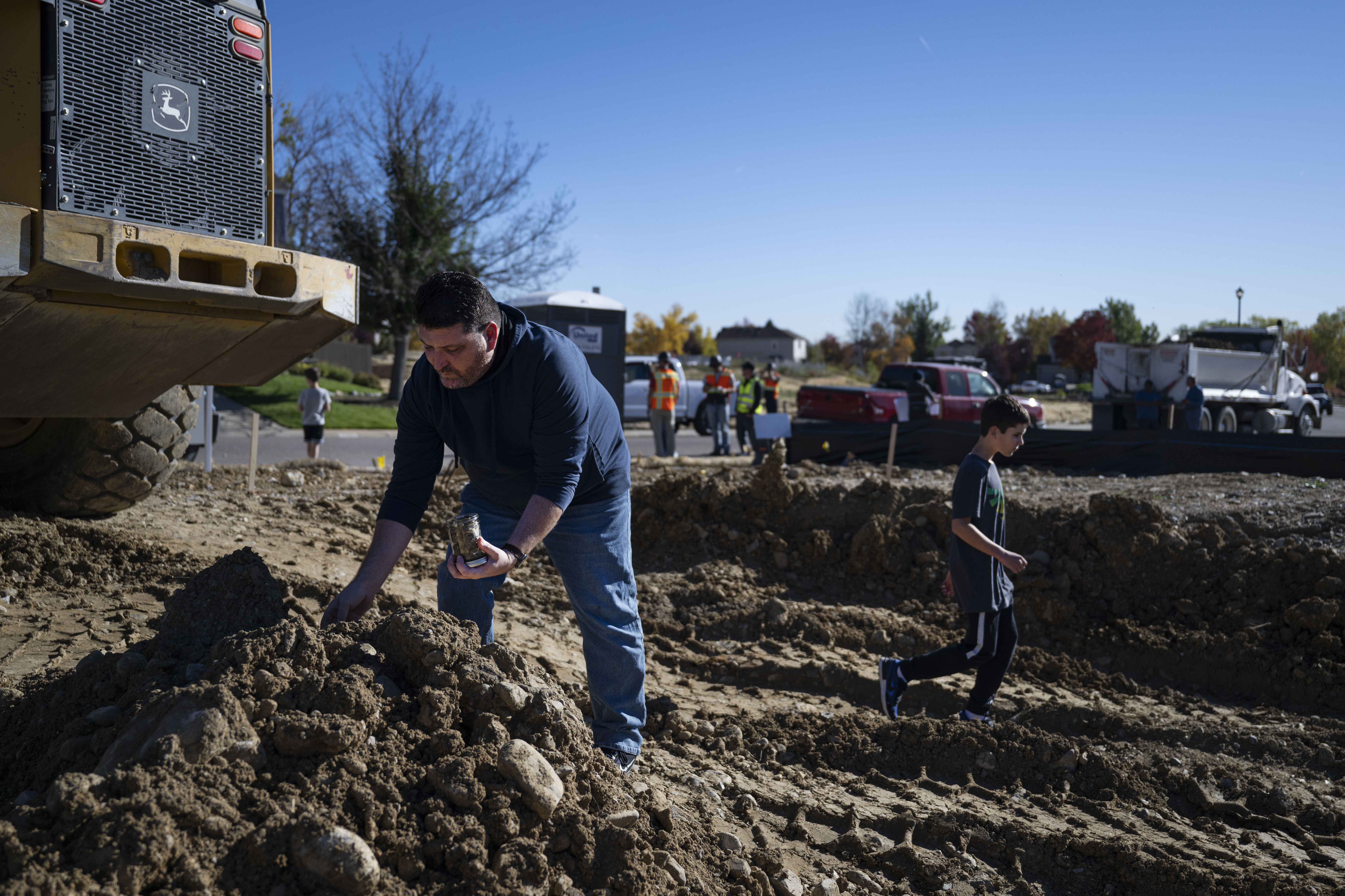 Chad Cheek, who’s family lost their home in the Marshall Fire in 2021, collects a jar of soil from the site of their home while one of his sons Nathan, 14, walks through what used to be their basement before a bulldozer begins excavating the property for their new home on Wednesday, Oct. 19, 2022, in Superior, Colo. Cheek plans to send some of the soil to his mother, who’s birthday is today, and keep the rest as a memento. (Timothy Hurst/The Denver Gazette) (TimHursttim.hurst@gazette.comhttps://secure.gravatar.com/avatar/aca82bd62b4ee425c598527cd6faa1b1?d=mm&r=g)