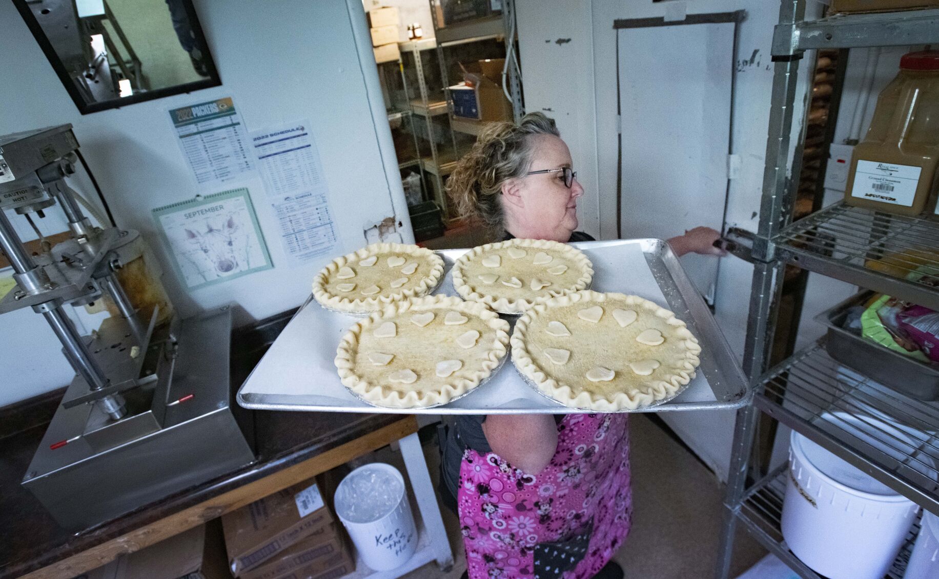Baking manager Kris Quartermus moves freshly prepared cherry pies into the walk-in refridgerator before cooking at the Colorado Cherry Co. Tuesday, Sept. 27, 2022, outside Lyons restaurant. (The Gazette, Christian Murdock) (Christian Murdock/The Gazette)