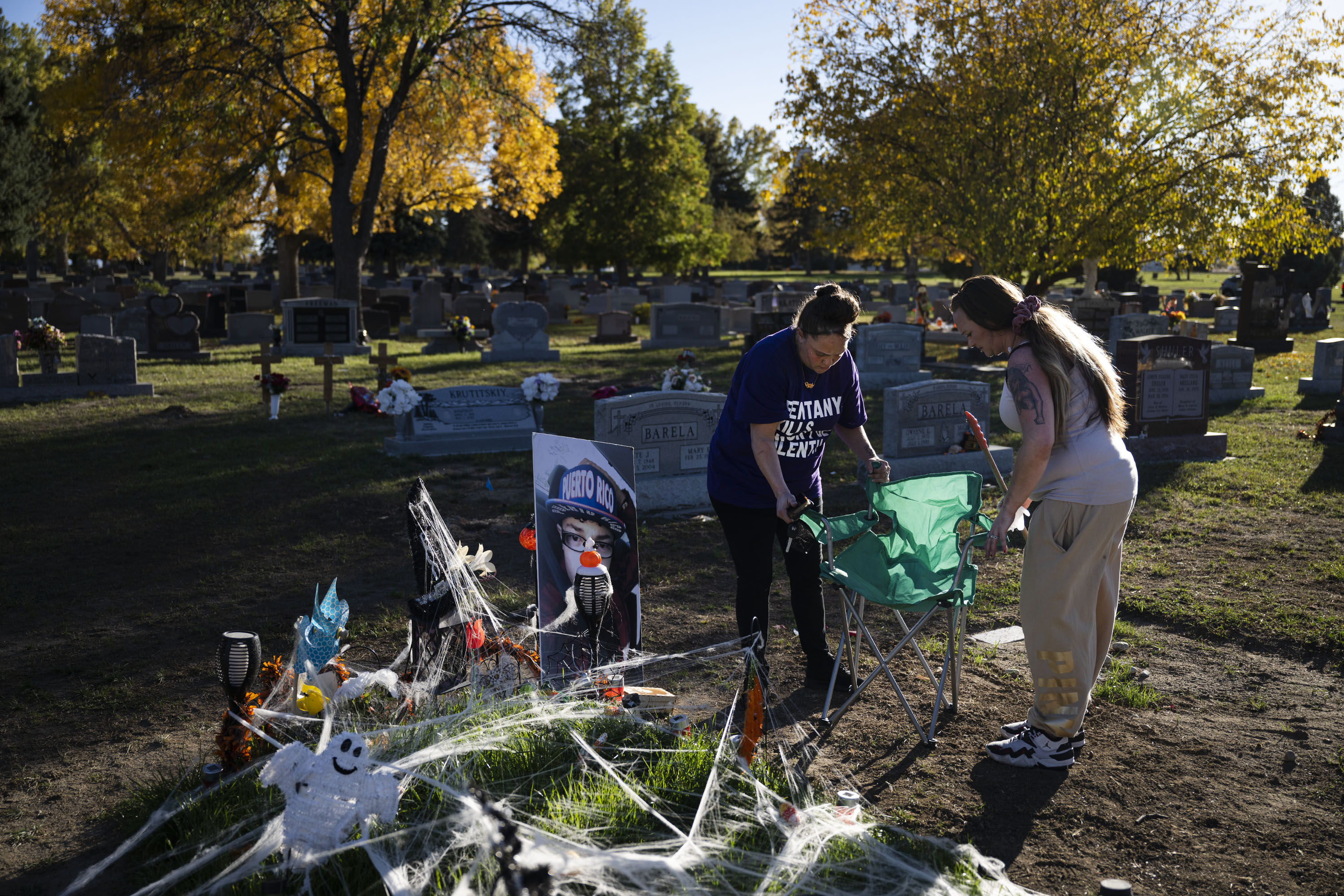 Christina Luna, the mother of Josiah Velasquez, left, and her close friend and sister Tara Garcia set up camping chairs to spend time at Josiah’s grave that’s been decorated for Halloween on Thursday, Oct. 20, 2022, at the Crown Hill Cemetery in Lakewood, Colo. Luna and Garcia visit the site often and bring a large photo of Josiah with them each time they visit. (Timothy Hurst/The Gazette) (TimHursttim.hurst@gazette.comhttps://secure.gravatar.com/avatar/aca82bd62b4ee425c598527cd6faa1b1?d=mm&r=g)