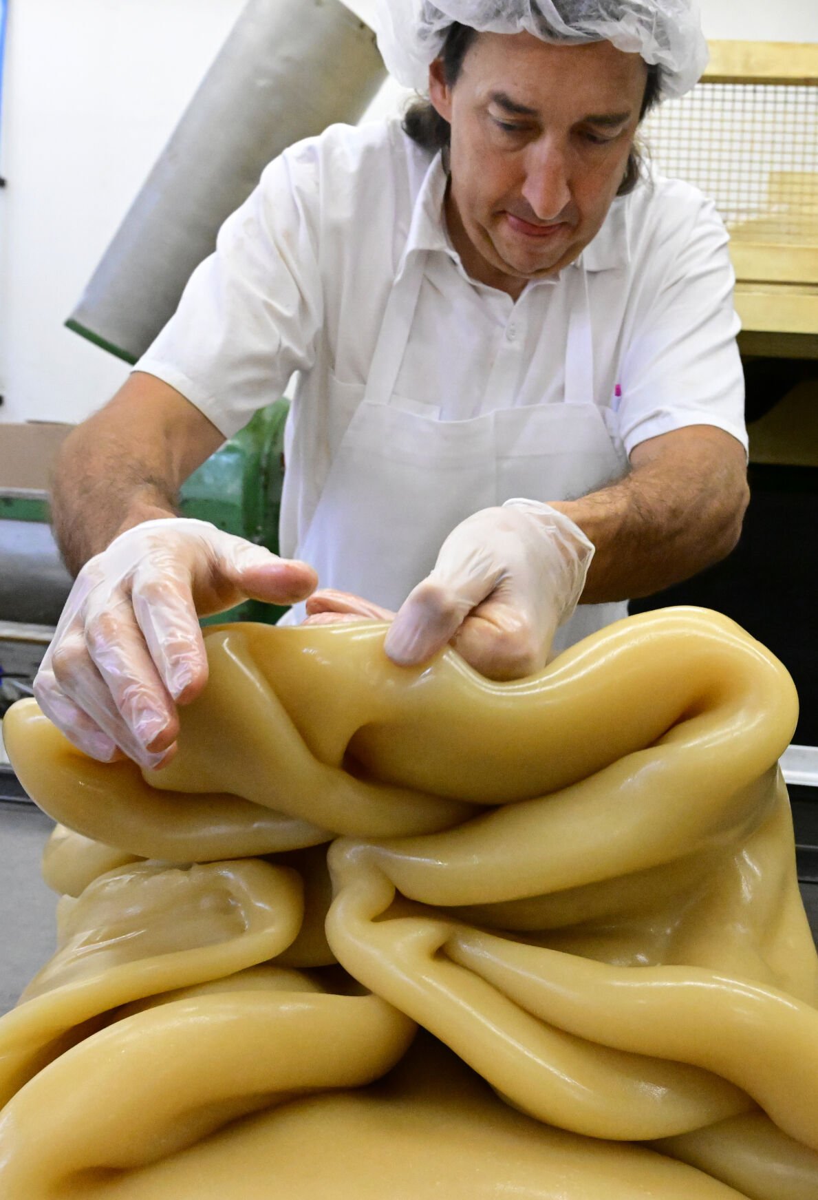 Si Niswonger folds 100 pounds of taffy before putting it on the pulling machine at Patsy’s Candies last month. (photos by Jerilee Bennett, the gazette)