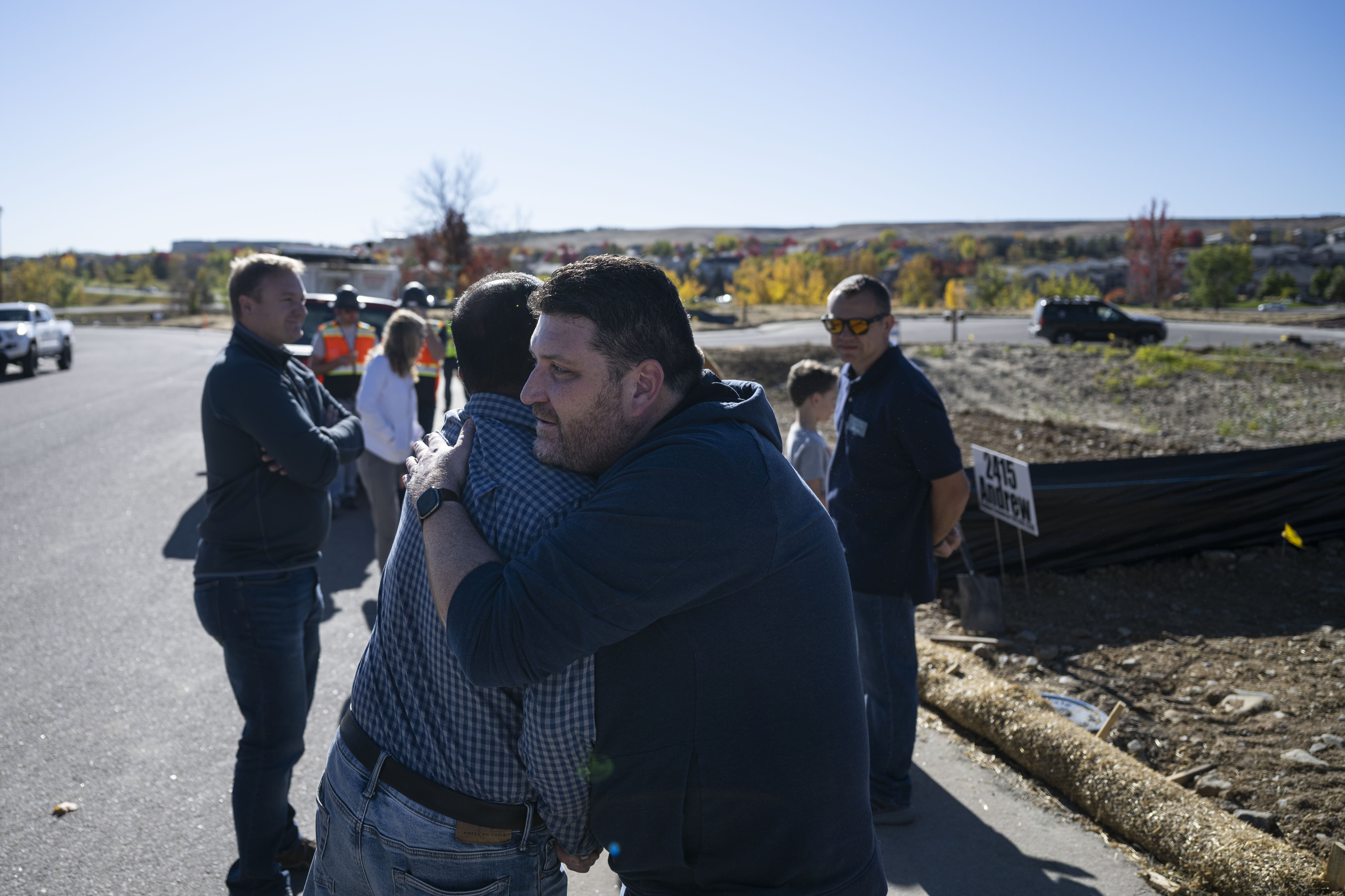 Chad Cheek, right, hugs his neighbor from two houses down, Kali Prasad, before a bulldozer begins excavating Cheek’s property for their new home on Wednesday, Oct. 19, 2022, in Superior, Colo. Multiple neighbors came out to see the groundbreaking to begin construction on Cheek’s home, one of many lost in the neighborhood to the Marshall Fire in 2021. Prasad’s property is slated to be the next one excavated. (Timothy Hurst/The Gazette) (TimHursttim.hurst@gazette.comhttps://secure.gravatar.com/avatar/aca82bd62b4ee425c598527cd6faa1b1?d=mm&r=g)