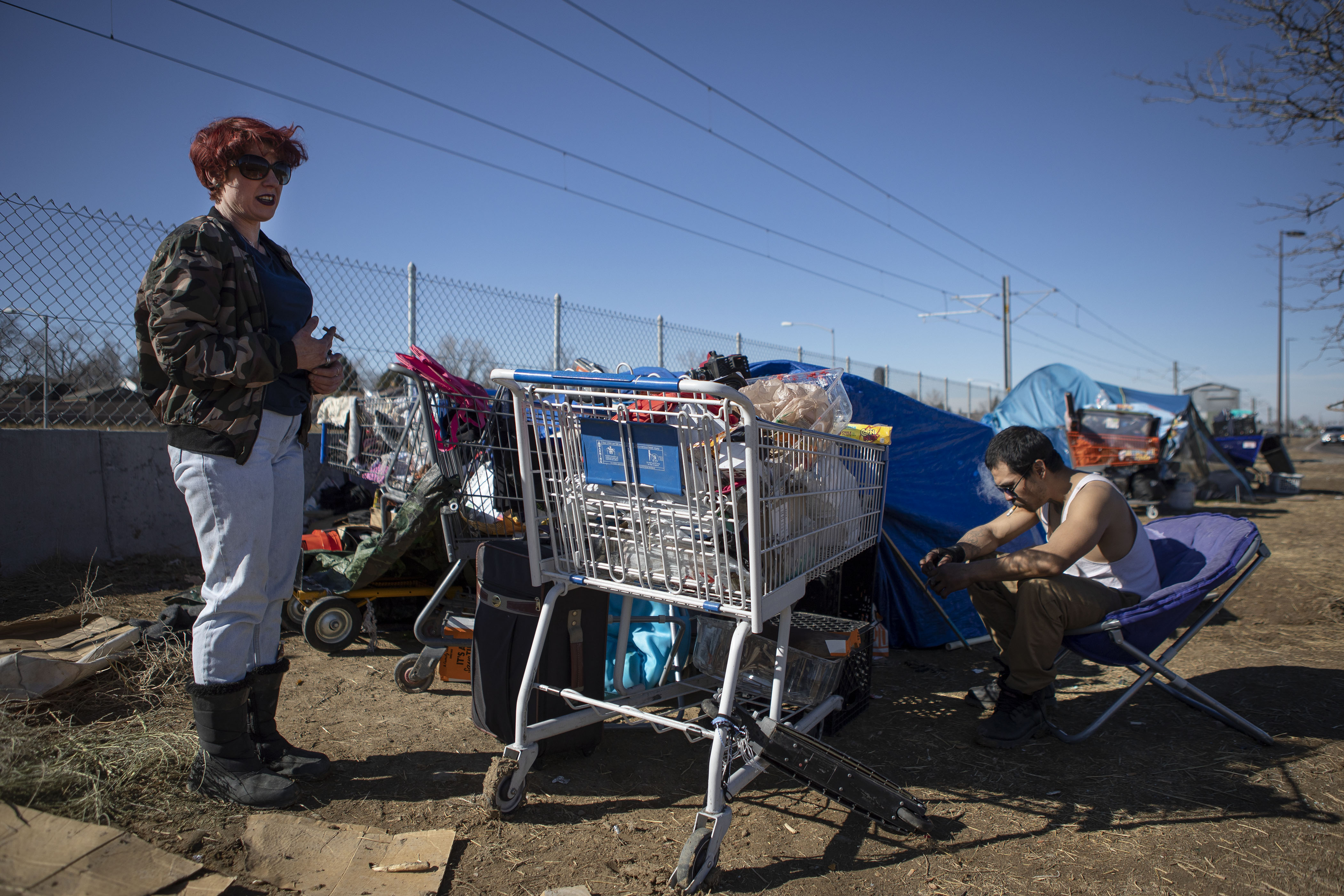 Angel, left, and friend Sleepy discuss the difficulties of living in a camp after picking up trash between their site and a neighboring site on Monday, Feb. 28, 2022, near I-225 and East Mississippi Avenue in Aurora, Colo. Angel has stacked up debris around her tent to help insulate it from the wind. (Timothy Hurst/The Denver Gazette) (Timothy Hurst)