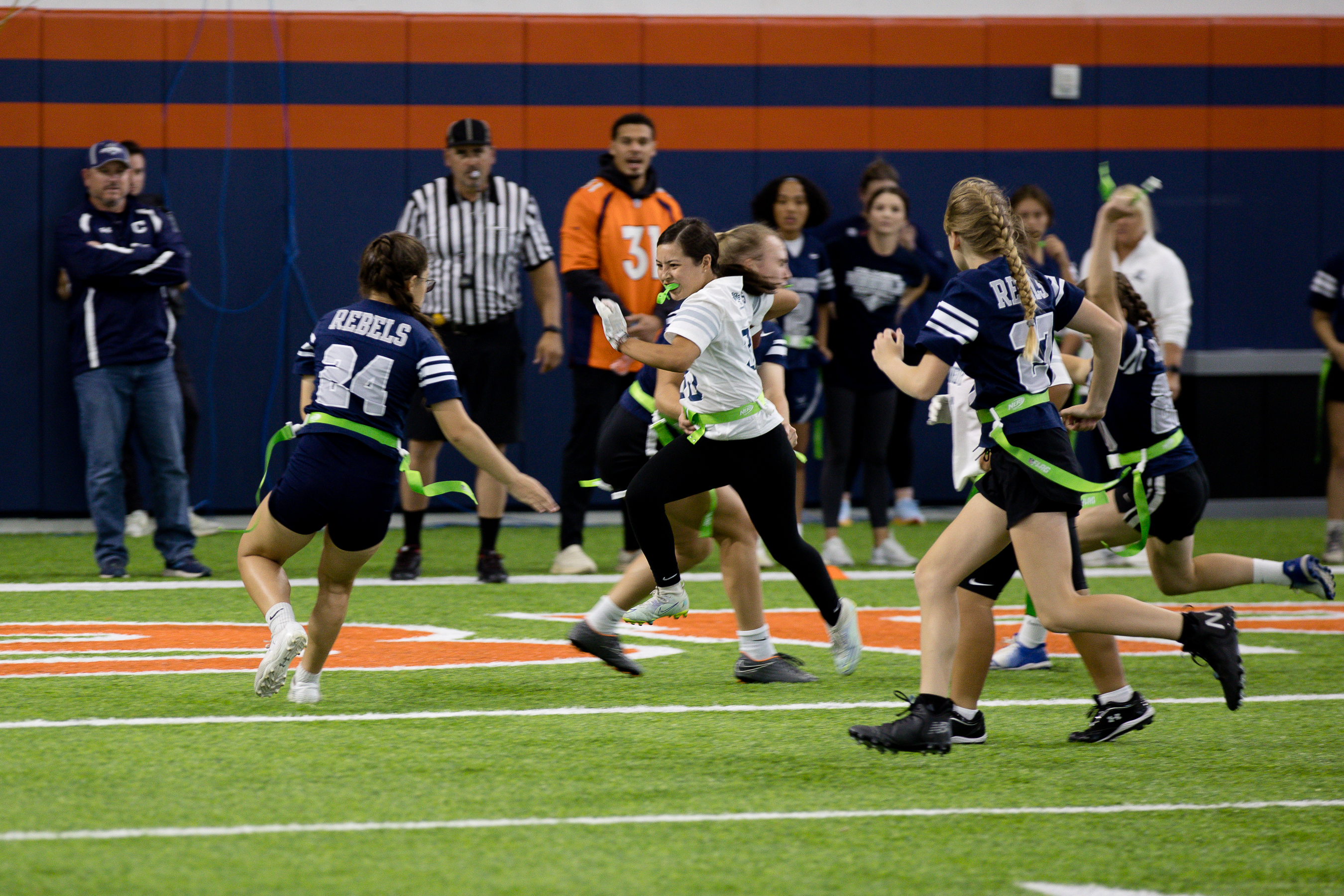The Columbine Rebels surround Kennedy High School player as she attempts to run through them without losing a flag. (Sara Hertwig/for The Denver Gazette)