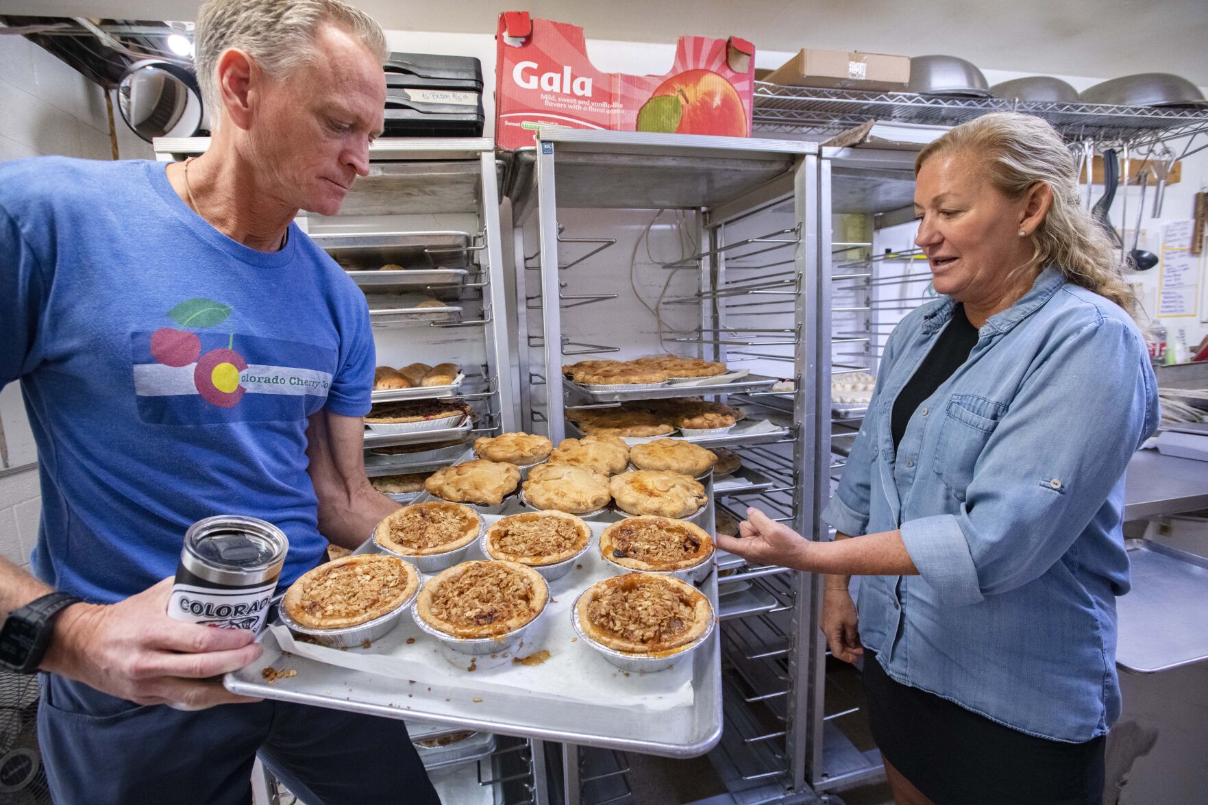Anthony and Kristi Lehnert hold a tray of freshly cooked individual pies in the kitchen at the Lyons location of Colorado Cherry Co. The Lehnert family was been baking pies for four generations. (photos by Christian Murdock, The Gazette)