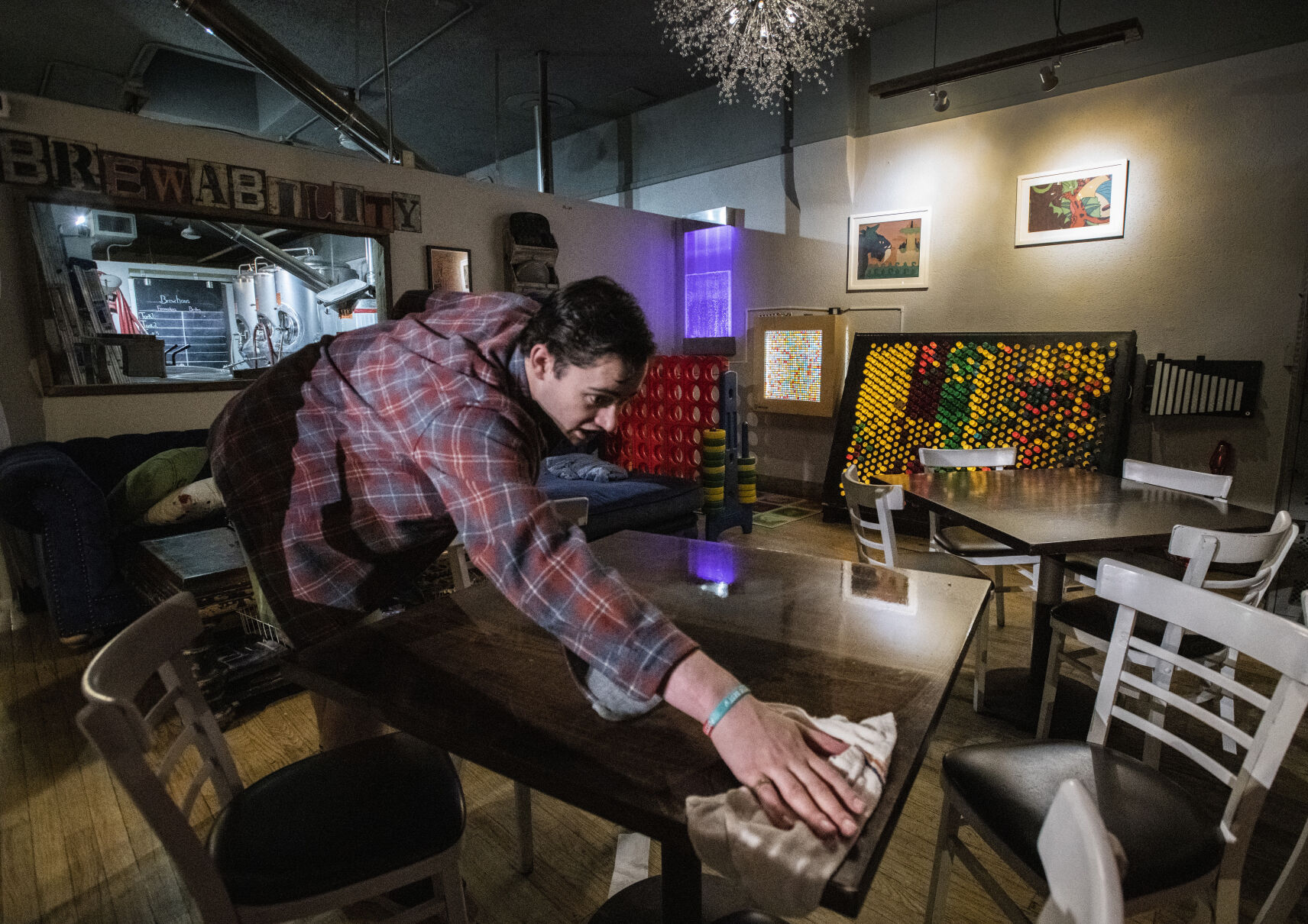 Michael Newland wipes down a table in the sensory room of Brewability in South Broadway. (Christian Murdock,The Gazette)