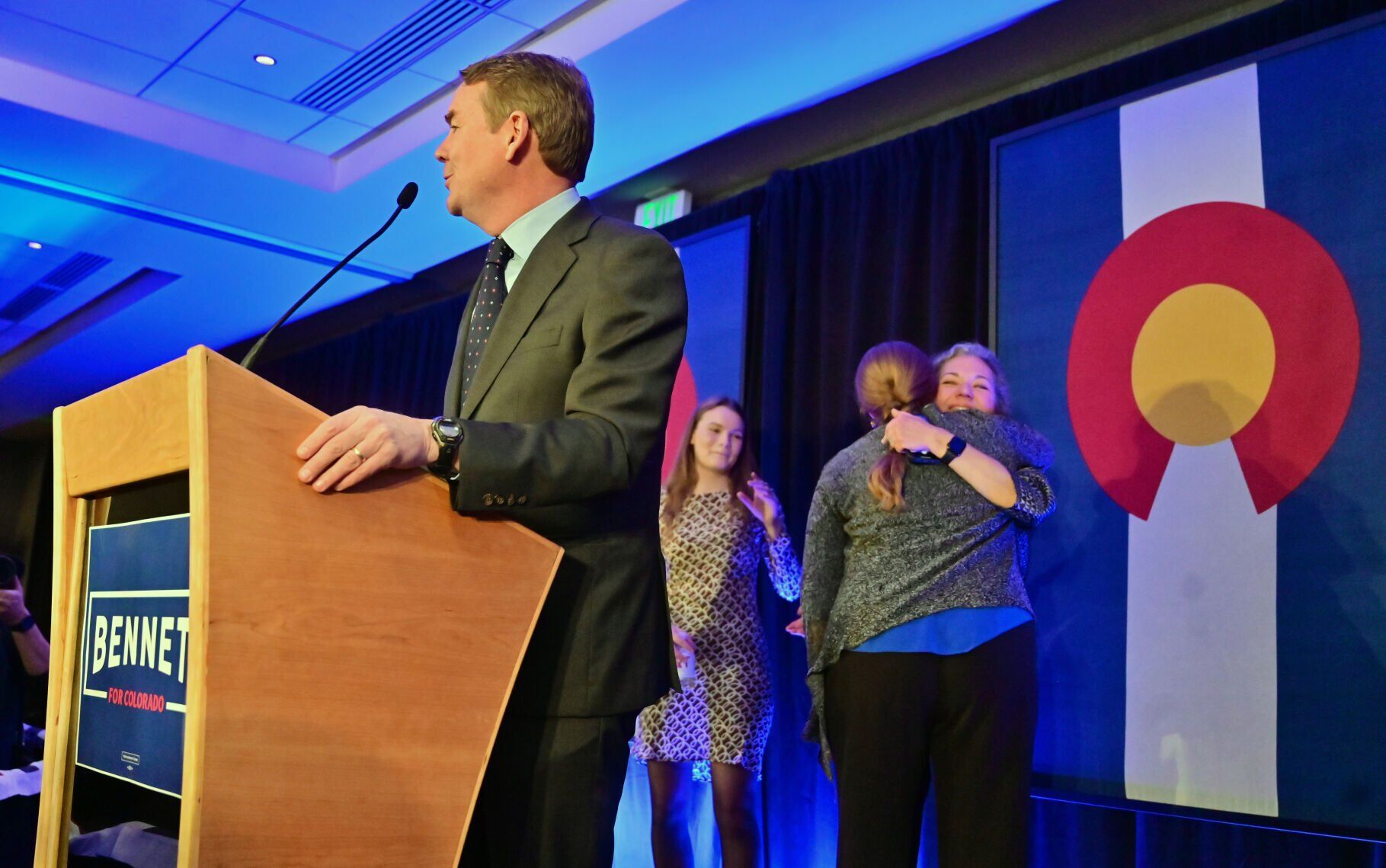U.S. Sen. Michael Bennet gives his victory speech as his wife, Susan Daggett gets a congratulatory hug on election night at the Democratic watch party at the Art Hotel on Tues., Nov. 8, 2022. (Photo by Jerilee Bennett, The Gazette)