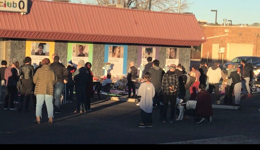 Mourners gather around the memorial for the victims of last Saturday's shooting at Club Q. The memorial was moved from curbside to the front of the club on Friday, Nov. 25, 2023. (O'Dell Isaac, The Gazette)