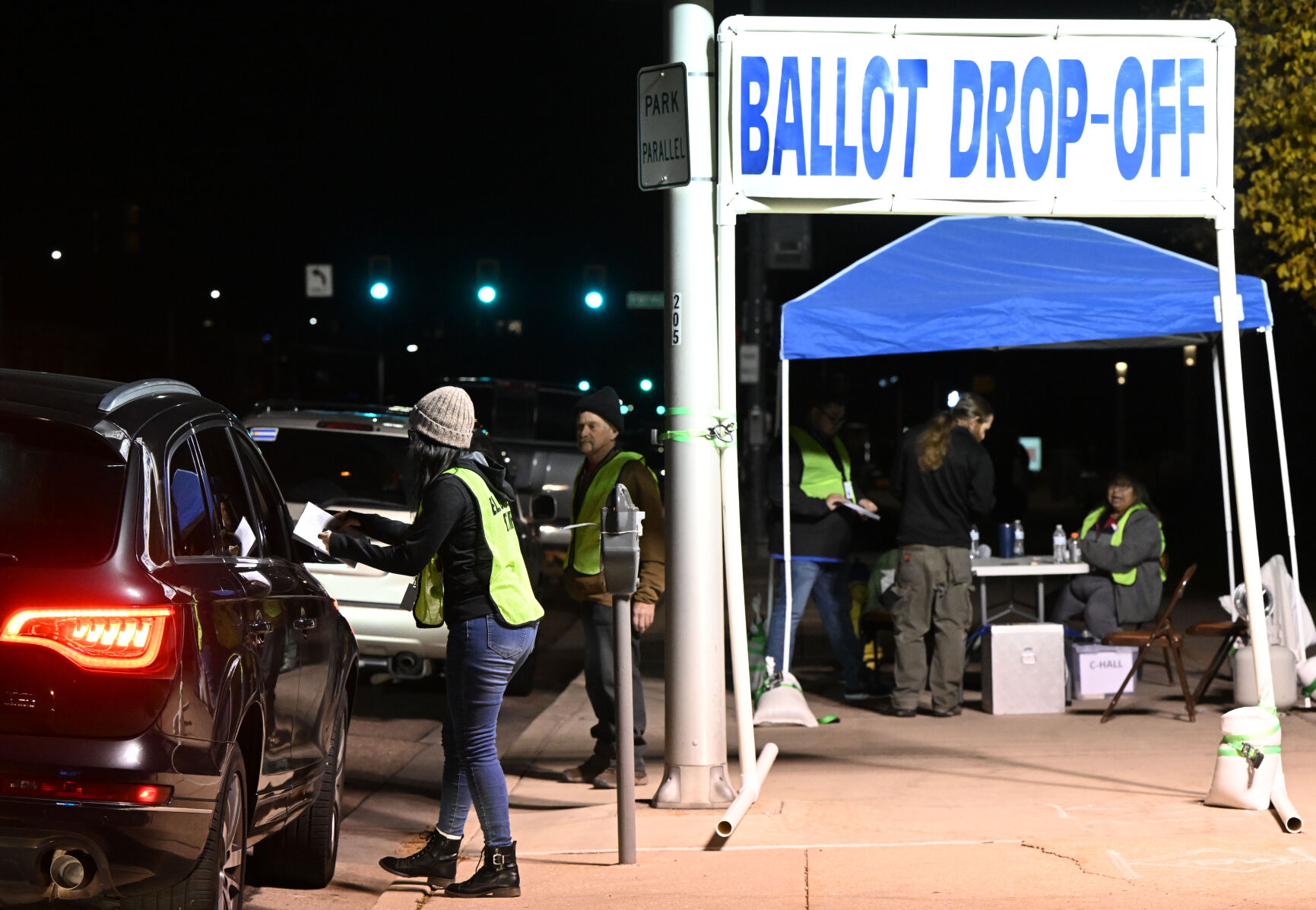 Election worker Jennifer Sharp collects a ballot as cars line up in front of Centennial Hall Tuesday, Nov. 8, 2022, in the final hours of voting in Colorado Springs. (The Gazette, Christian Murdock) (Christian Murdock/The Gazette)