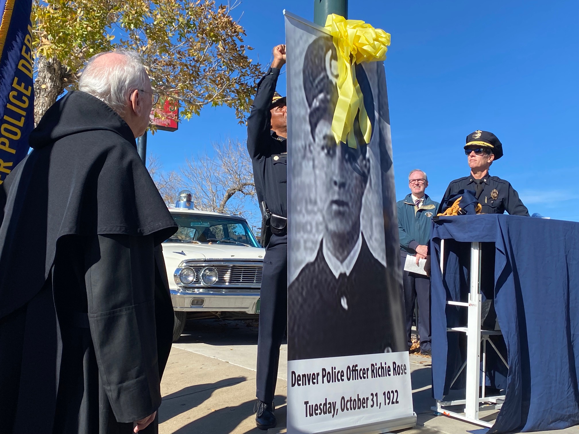A photo of Denver Police officer Richie Rose adorned with a yellow ribbon accompanies a program about his short life of service. Rose was gunned down at the corner of 38th and Lipan, where a Chubbies restaurant now stands, on Oct. 31, 1922. (Carol McKinley)