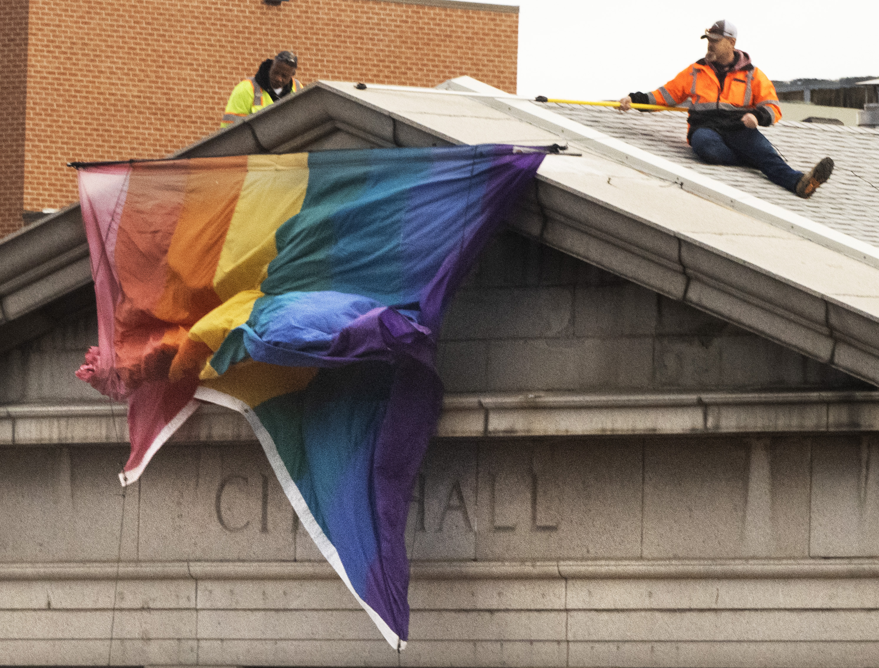 City workers drop the flag from the top of Colorado Springs City Hall during a ceremony honoring the victims of the Club Q shooting on Wednesday, Nov. 23, 2022. The historical flag was the same one that flew over Pulse nightclub and at the White House. It was be hanging there for two weeks. (Photo by Jerilee Bennett, The Denver Gazette) (JerileeBennettjerilee.bennett@gazette.comhttps://secure.gravatar.com/avatar/a400b0ac348f1407dc2709999dc38d3b?d=mm&r=g)