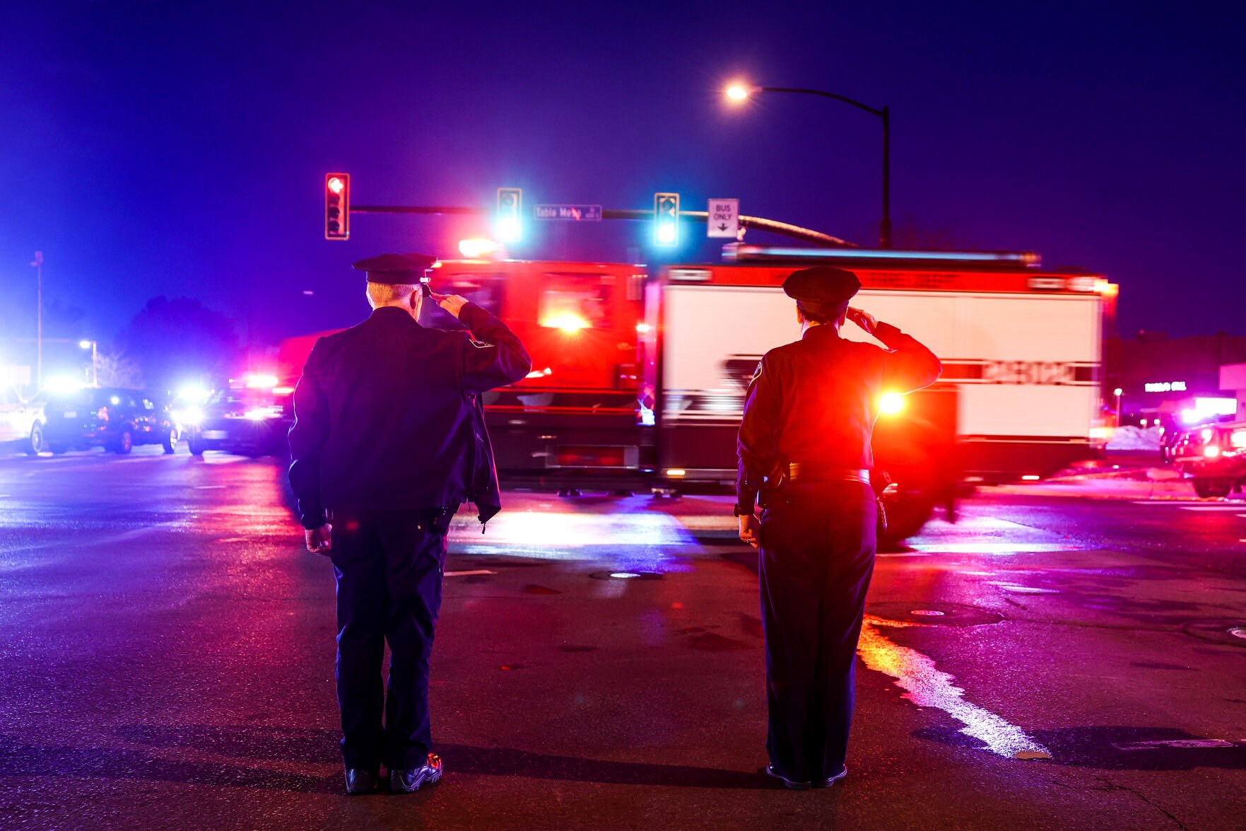 Police officers salute as emergency vehicles escort the body of a slain police officer from the scene of a shooting at a King Soopers on Monday, March 22, 2021 in Boulder. Ten people were killed in the shooting. (Michael Ciaglo/Special to The Denver Gazette) (Michael Ciaglo/Special to The De)