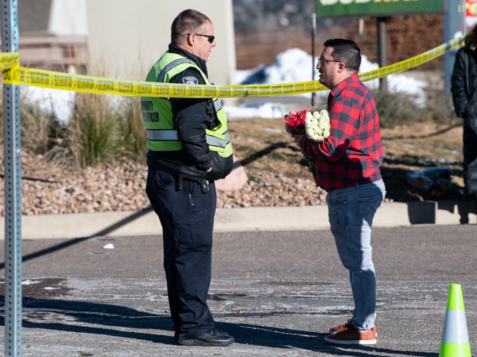 Jace Khosla, right, talks to an officer outside of Club Q where a mass shooting took place late on Saturday, Nov. 19. (The Gazette, Parker Seibold) (Parker Seibold)