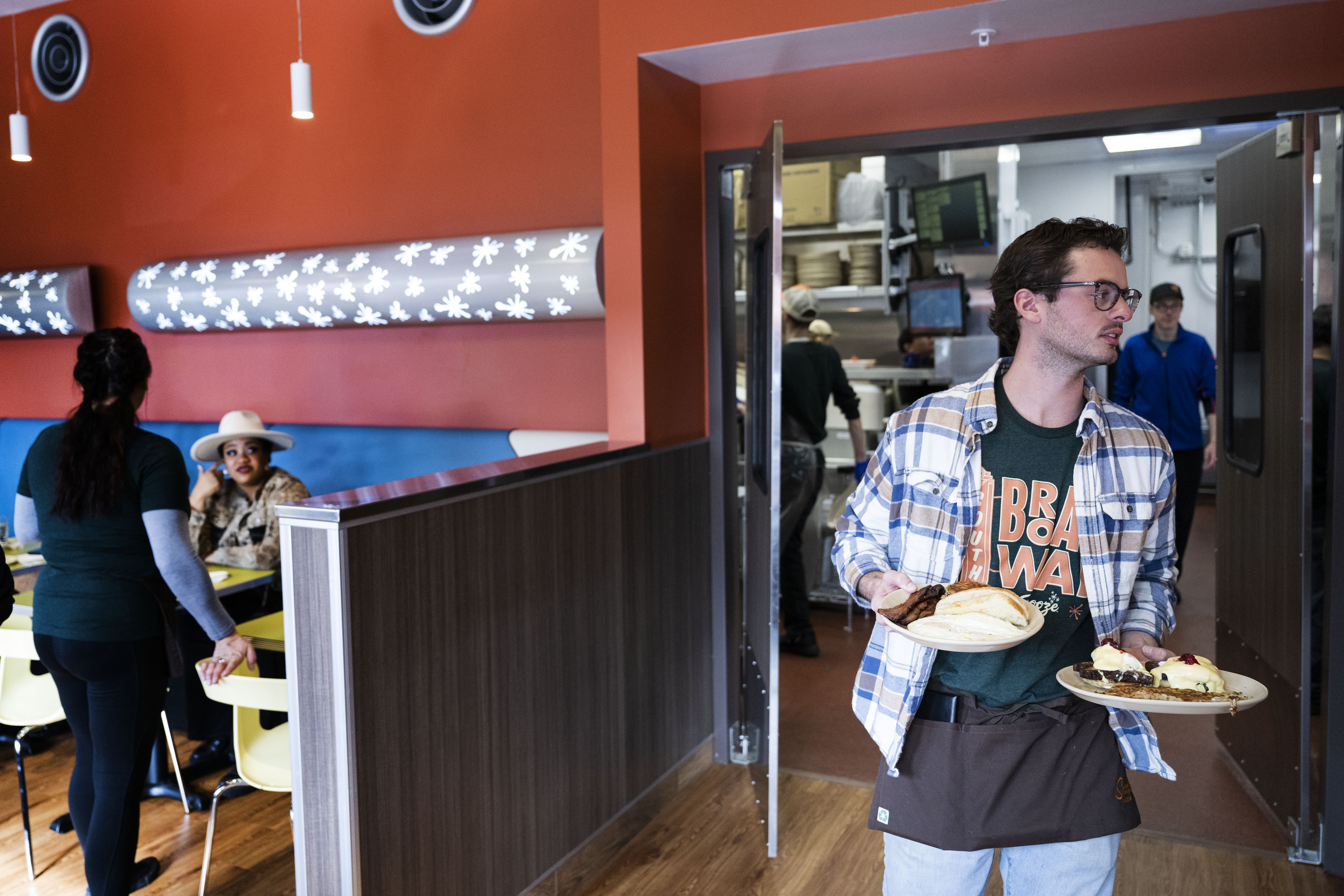 Server Conner Harrigan carries a customer’s order from the kitchen at Snooze an A.M. Eatery on Wednesday, Nov. 16, 2022, on North Broadway in Denver. (Timothy Hurst/The Gazette) (TimHursttim.hurst@gazette.comhttps://secure.gravatar.com/avatar/aca82bd62b4ee425c598527cd6faa1b1?d=mm&r=g)