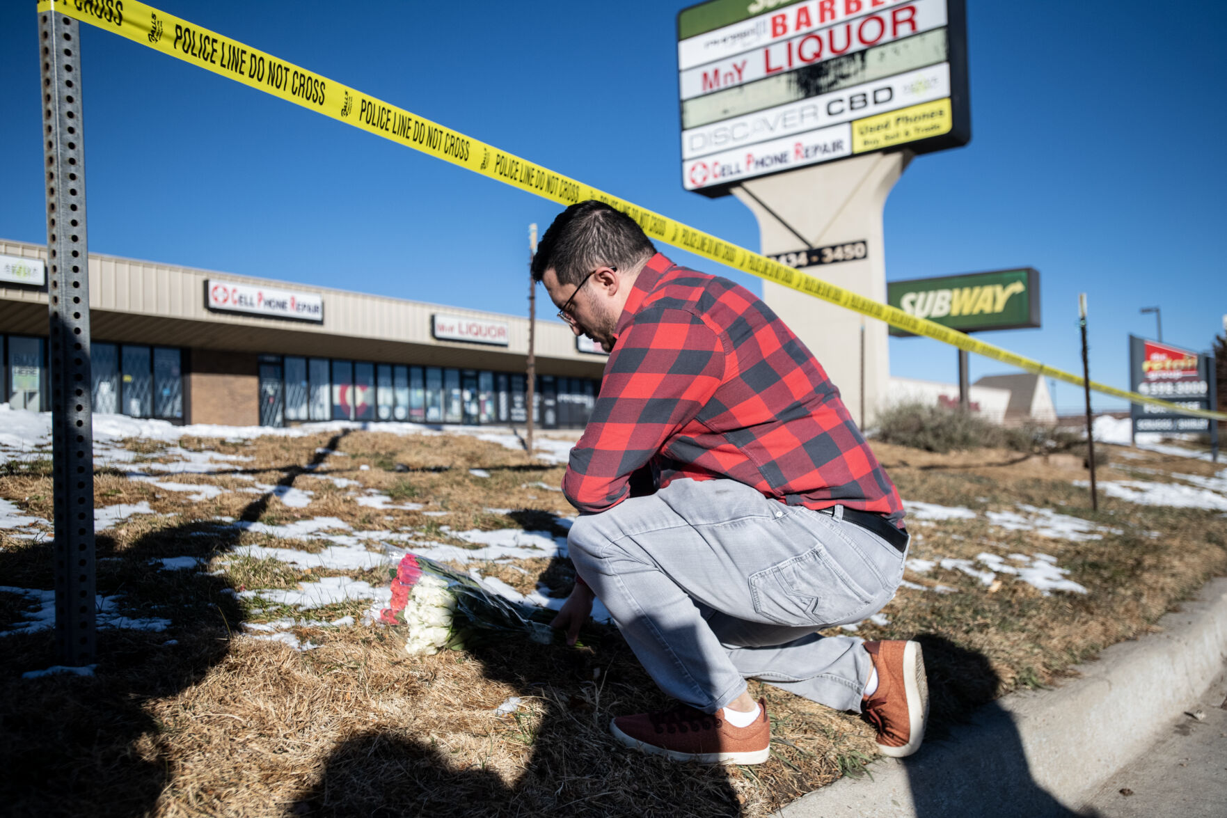 Jace Khosla places flowers outside the police tape surrounding Club Q, a gay bar where a mass shooting took place late on Saturday, Nov. 19. Khosla is from Pueblo and said many of his friends frequent the bar and he’s still waiting to hear if anyone he knows was a victim. “I’m waiting for my phone to go off,” he said. (The Gazette, Parker Seibold) (Parker Seibold)