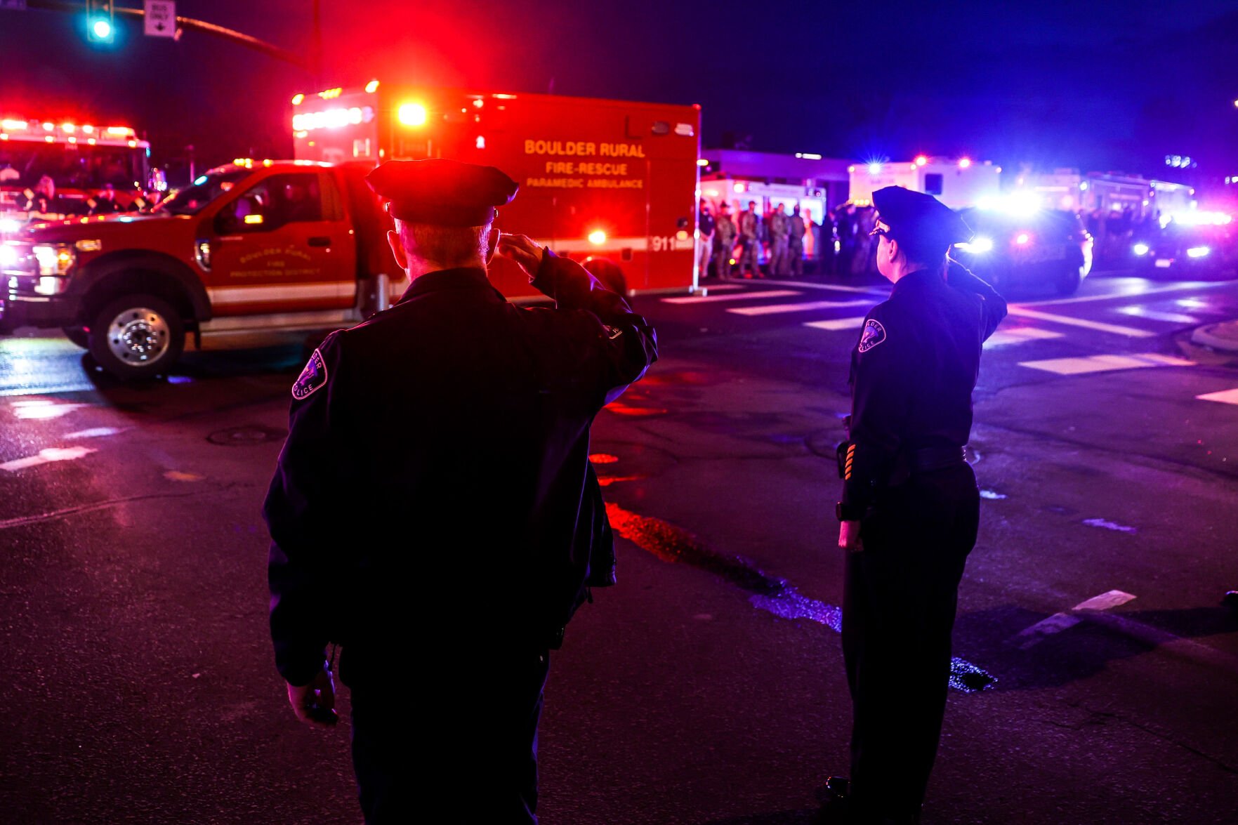 Police officers salute as emergency vehicles escort the body of a slain police officer from the scene of a shooting at a King Soopers on Monday, March 22, 2021 in Boulder. Ten people were killed in the shooting. (Michael Ciaglo/Special to The Denver Gazette) (Michael Ciaglo/Special to The De)