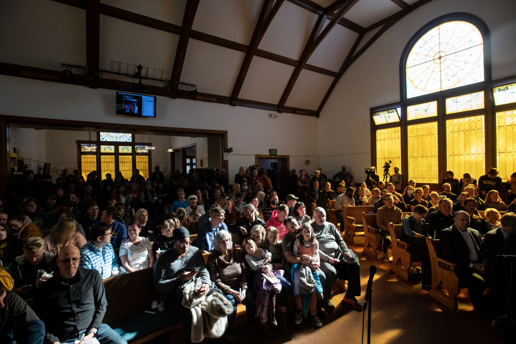 Light shines through the window of All Souls Unitarian Church illuminating community members that gathered for a service held for people to mourn following the mass shooting at Club Q in Colorado Springs, Colo., on Sunday, Nov. 20, 2022. (The Gazette, Parker Seibold) (Parker Seibold)