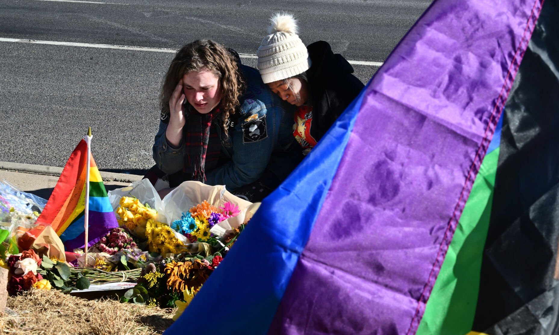 Zeth Gross and Keairra Barron comfort each other at the growing memorial of flowers and sentiments for the five people who were killed at Club Q on Saturday night. Both are regulars at the club. Monday, Nov. 21, 2022. (Photo by Jerilee Bennett, The Gazette)