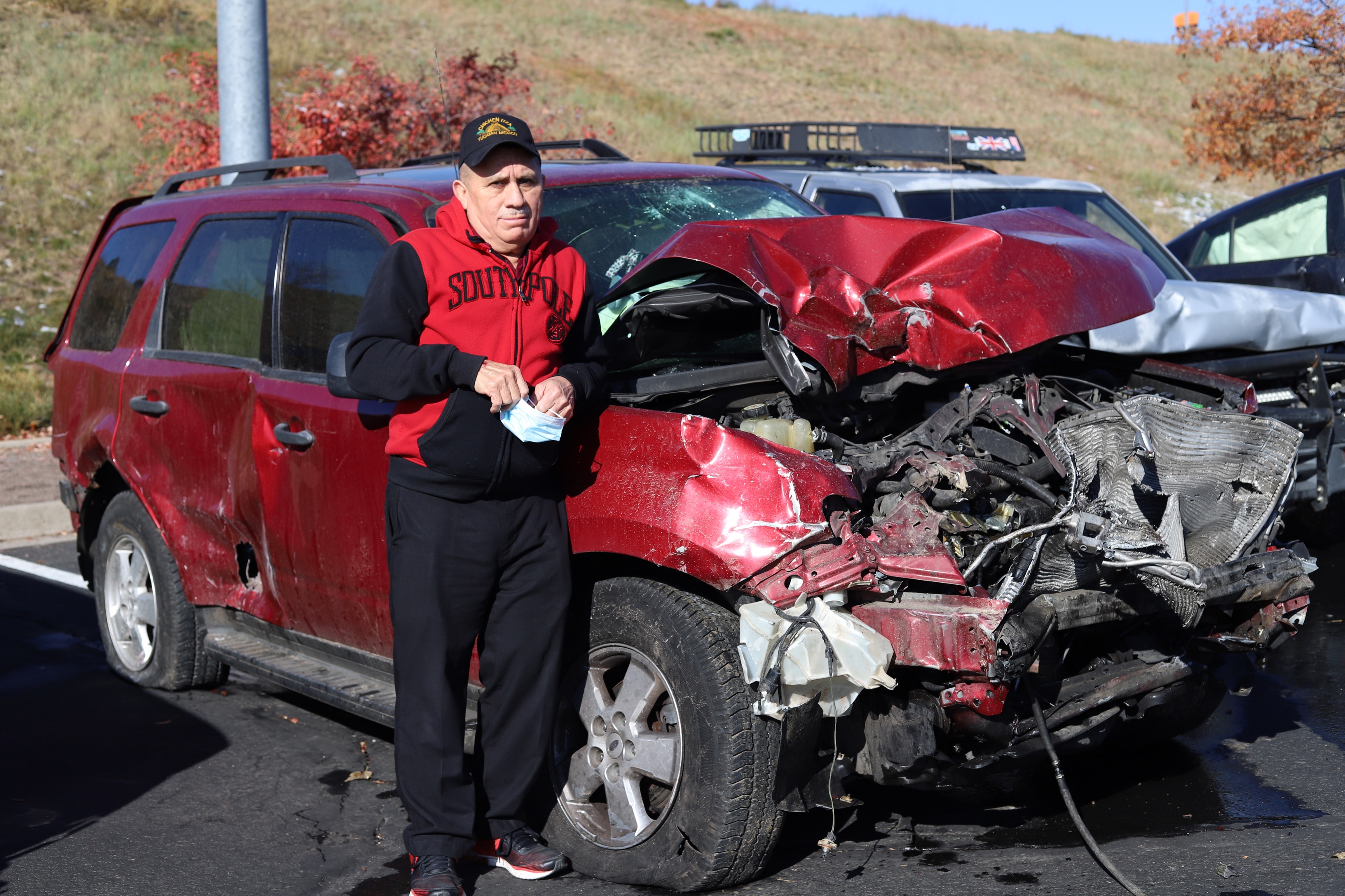 Feliciano Quintal stands in front of his totaled car following a 100-vehicle crash on 6th Avenue at I-25 Friday morning. (KYLA PEARCE/THE DENVER GAZETTE)