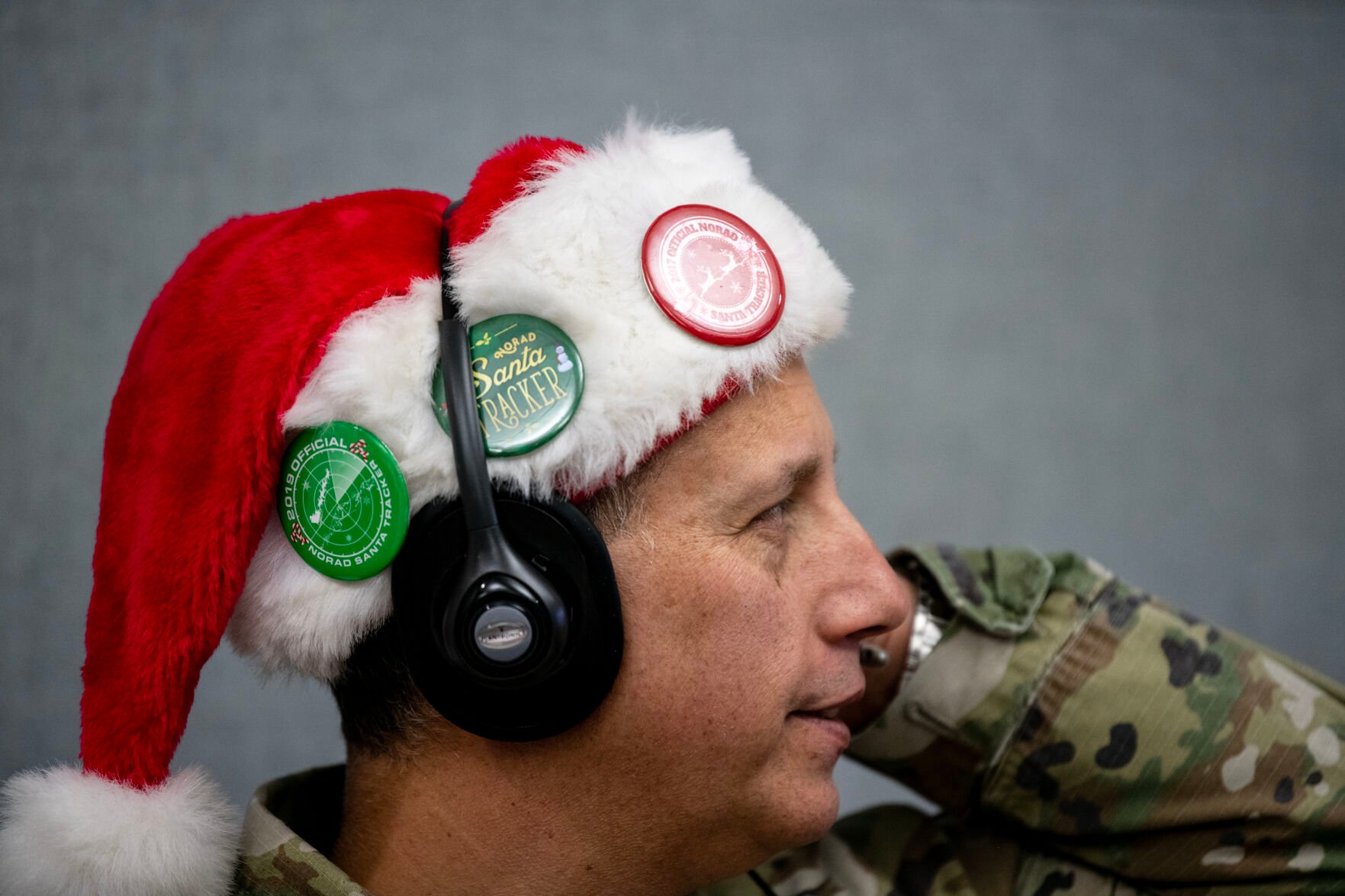 Master Sgt. Ken Melchi wears an array of Santa tracker pins on his hat as he speaks to a caller at the NORAD Tracks Santa Operations Center on Christmas Eve. Each year, volunteers work in two hour shifts on Christmas Eve to answer as many as 60,000 calls about Santa’s whereabouts. (The Gazette, Parker Seibold) (Parker Seibold)