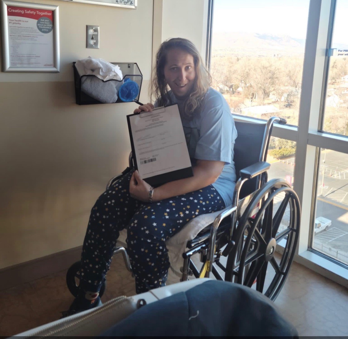 Charlene Slaugh was shot five times and lost half her blood in last month's Club Q shooting. She survived after many surgeries. In this photo, she is seen hamming for the camera with her hospital discharge papers. (COURTESY OF TINA SIEGFRIED)