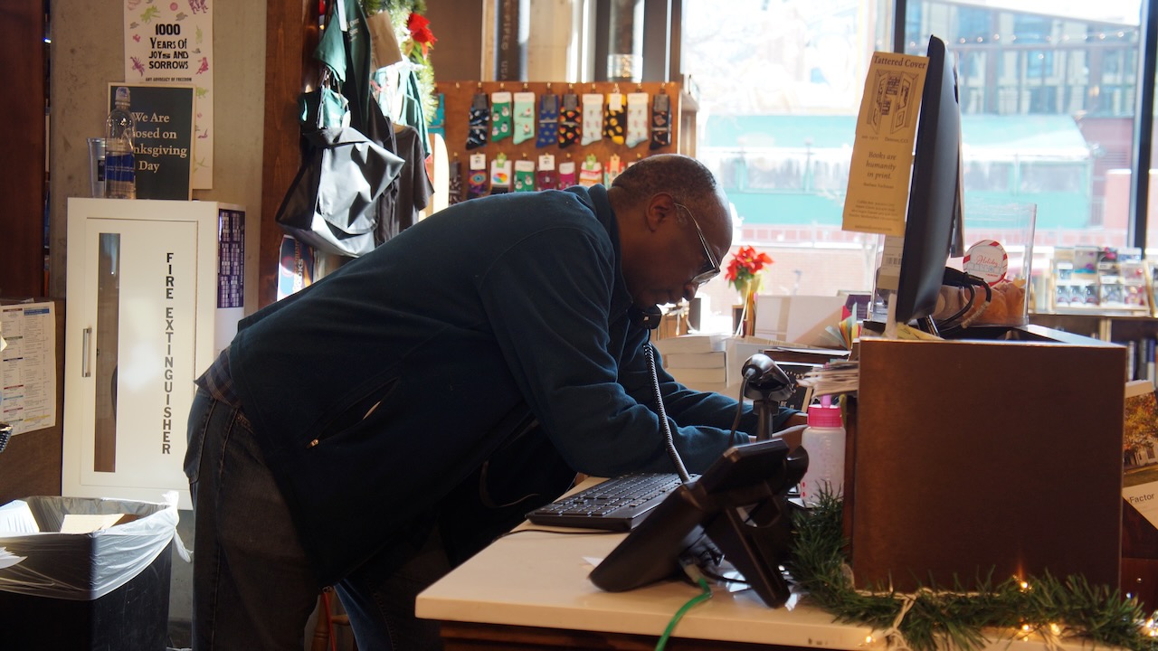 Derek Holland, manager of the McGregor Square Tattered Cover, speaks with a customer on the phone. He has worked at the Tattered Cover since 1989 and has fond memories of Joyce. (Alex Edwards, The Denver Gazette)