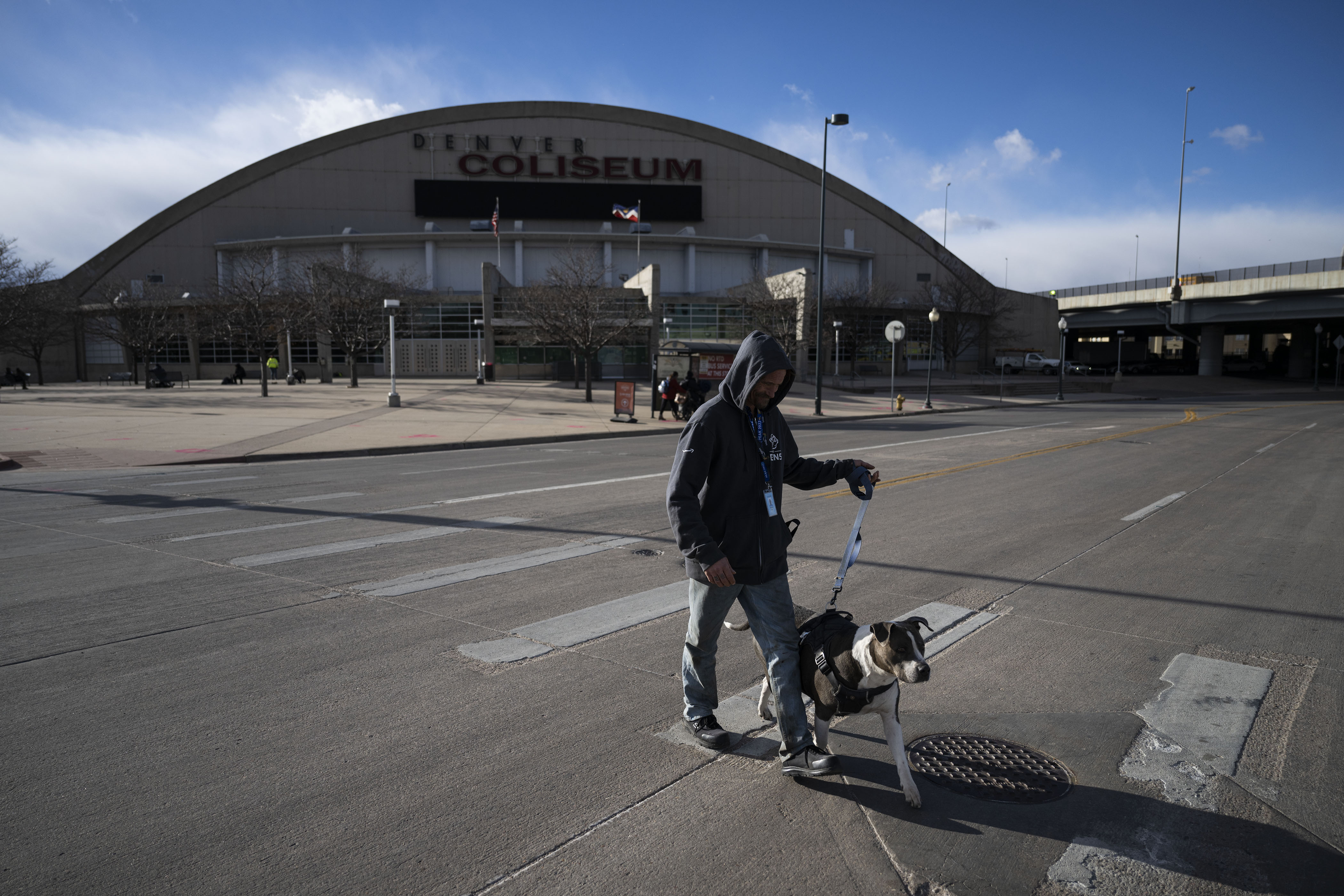 Rob Mays walks his and his wife Kate Mays’ 13-year-old service dog Shady across the street to go to the bathroom while waiting to be let into the Denver Coliseum. The arena opened as a 24-hour emergency warming shelter on Wednesday. (TimHursttim.hurst@gazette.comhttps://secure.gravatar.com/avatar/aca82bd62b4ee425c598527cd6faa1b1?d=mm&r=g)