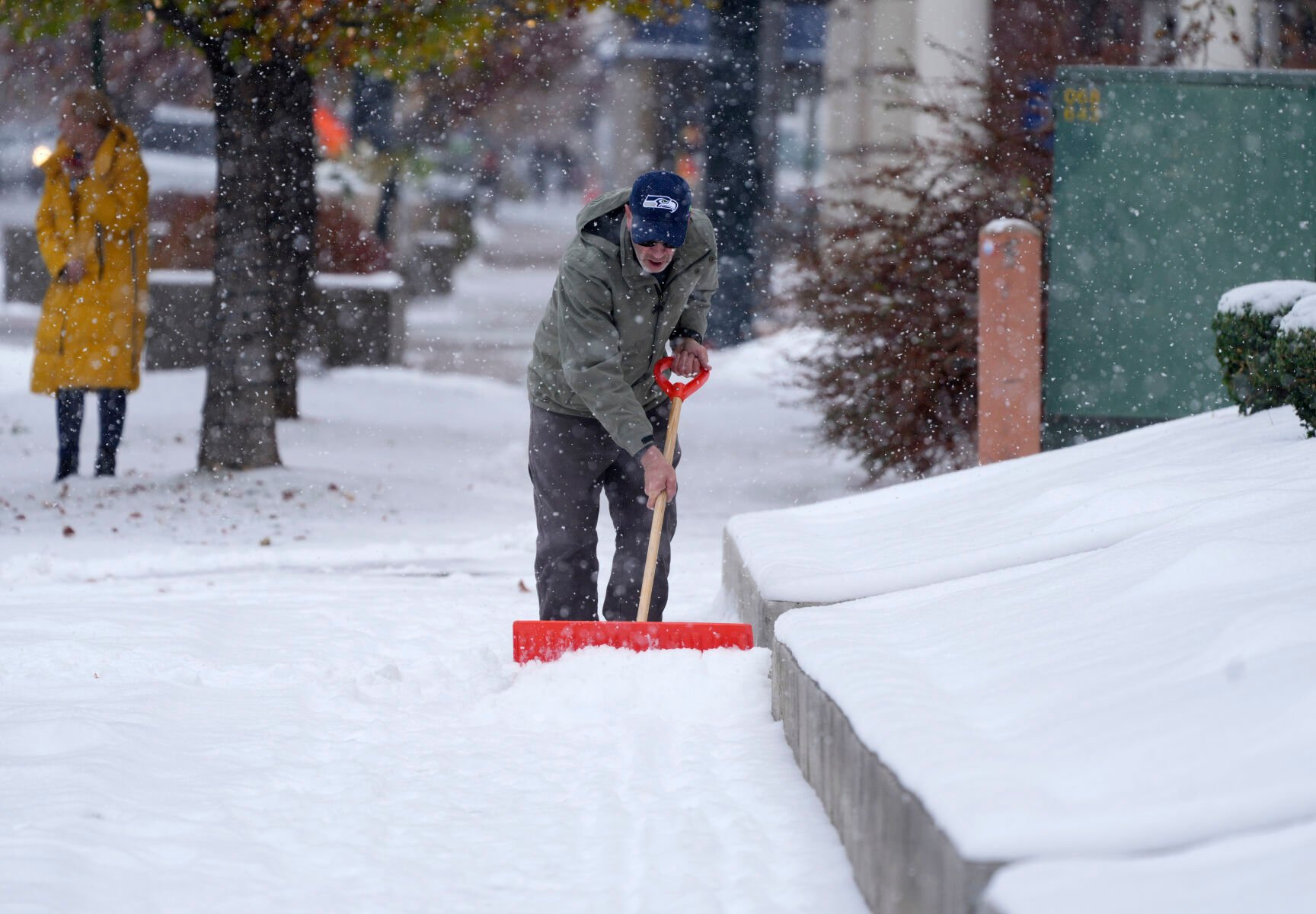 A Denver homeowner cleared snow from a walkway after a cold front packing subfreezing temperatures and light snow swept over the intermountain West Thursday, Nov. 17, 2022, in Denver. Forecasters predict that the cold temperatures will persist through Friday before relenting Saturday to more seasonal daytime highs. (DAVID ZALUBOWSKI/THE ASSOCIATED PRESS)