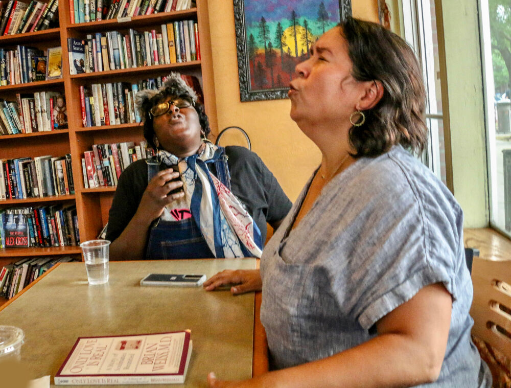 Sonsharae Tull, left, and GerRee Hinshaw bark like dogs in a short story they performed as part of a summer fundraiser for And Toto Too, one of two Denver theater companies that exist to produce work by female playwrights. (JOHN MOORE/DENEVR GAZETTE)