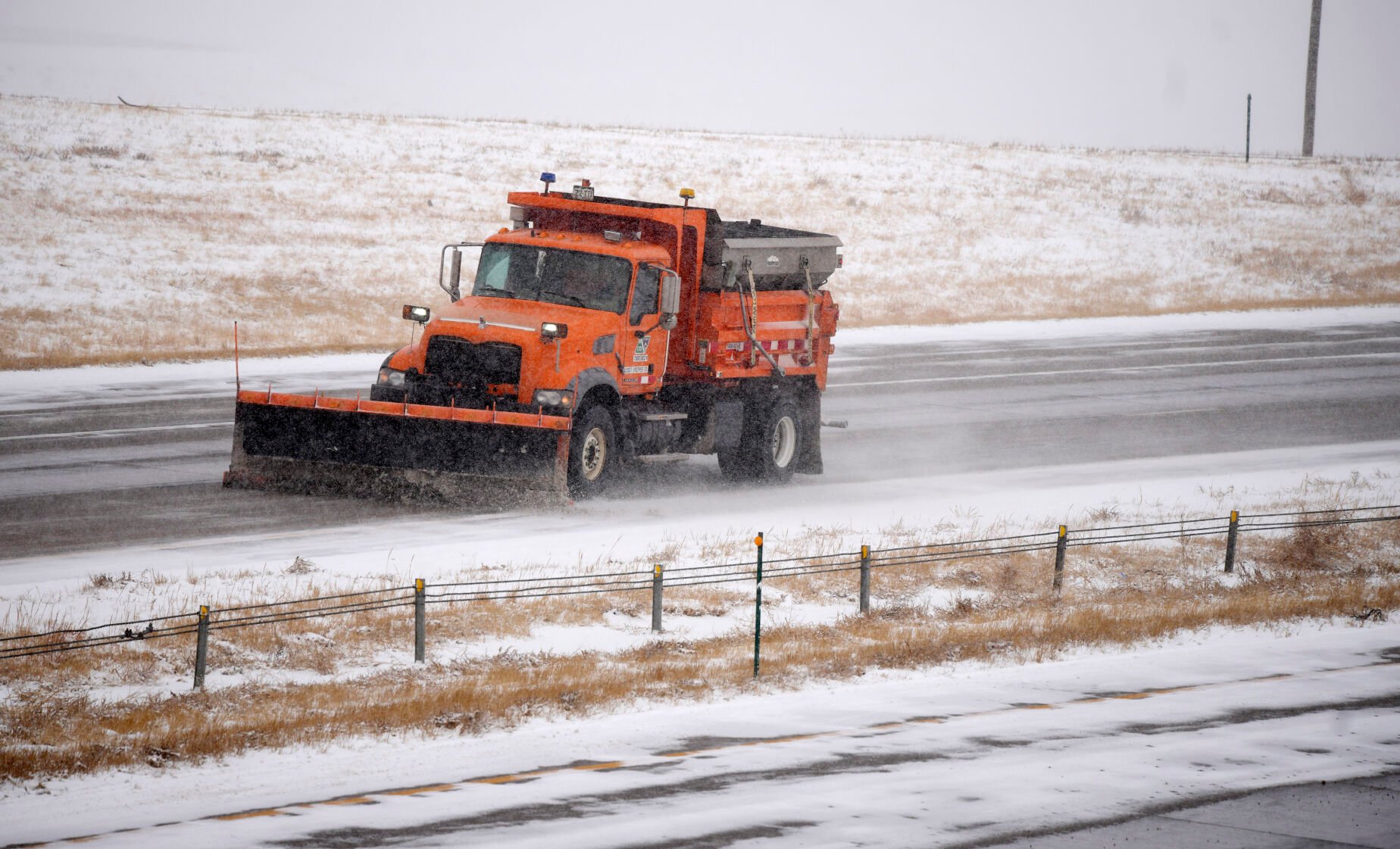 Colorado Department of Transportation snowplow carves a path along the westbound lanes of Interstate 70 near East Airpark Road, Tuesday, Dec. 13, 2022, in Aurora, Colo. (David Zalubowski - staff, AP)