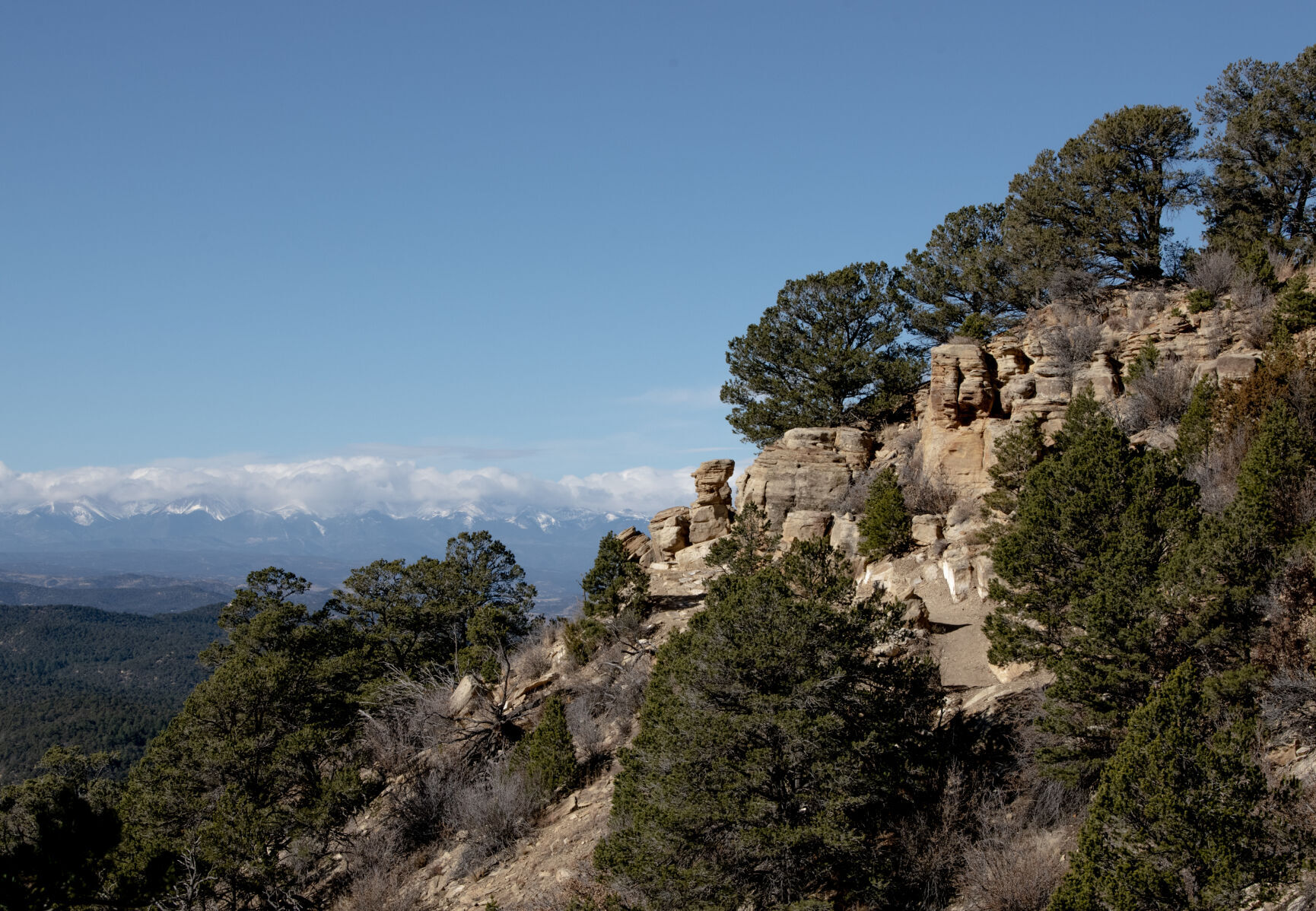 Snowcapped peaks are seen beyond sandstone bluffs at Fishers Peak State Park in Trinidad, Colo., on Tuesday, Dec. 6, 2022. (The Gazette, Parker Seibold) (Parker Seibold)