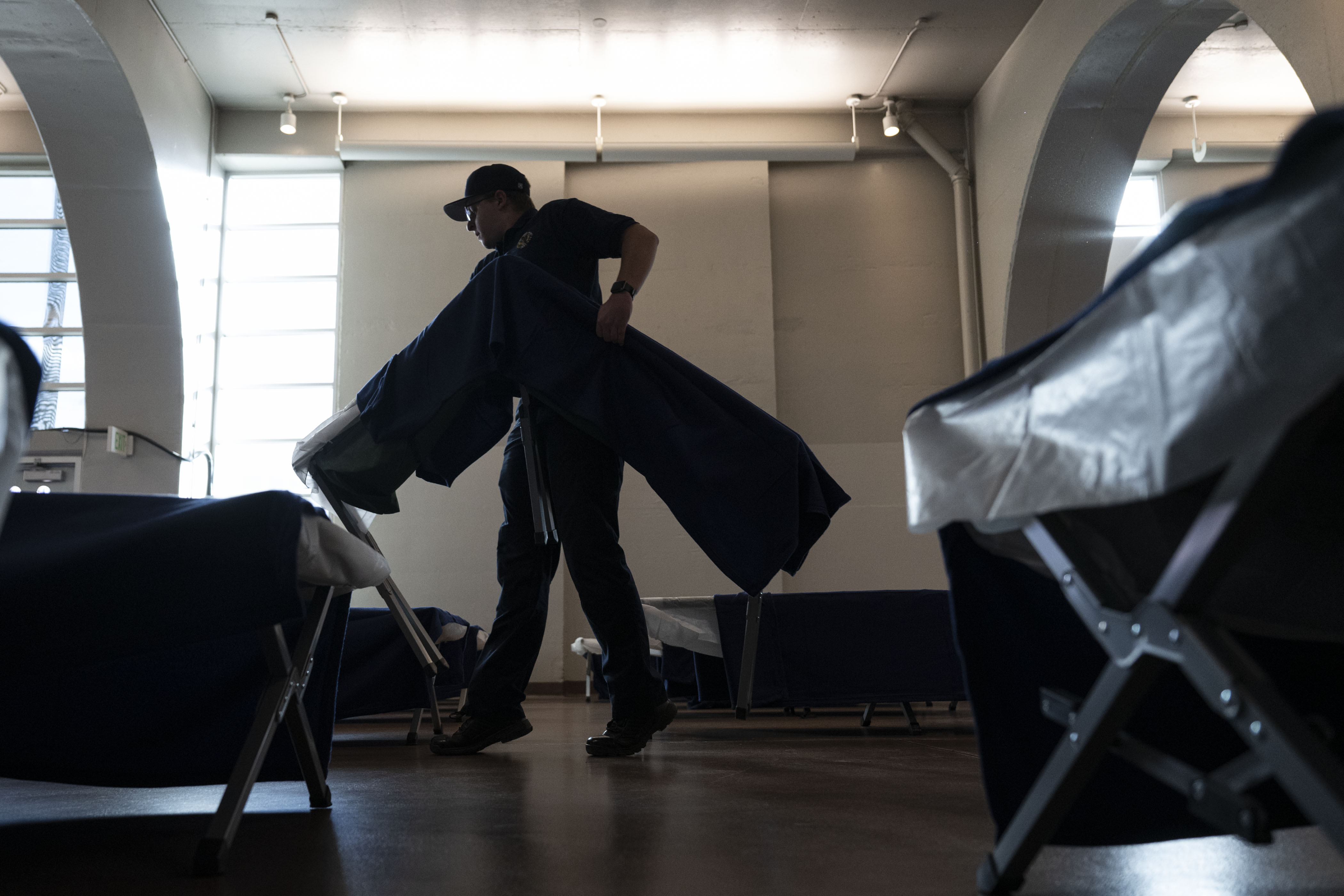 A member of the Public Safety Cadet Program rearranges cots in the outside hallways of the Denver Coliseum, which opened as a 24-hour emergency warming shelter on Wednesday. (TimHursttim.hurst@gazette.comhttps://secure.gravatar.com/avatar/aca82bd62b4ee425c598527cd6faa1b1?d=mm&r=g)
