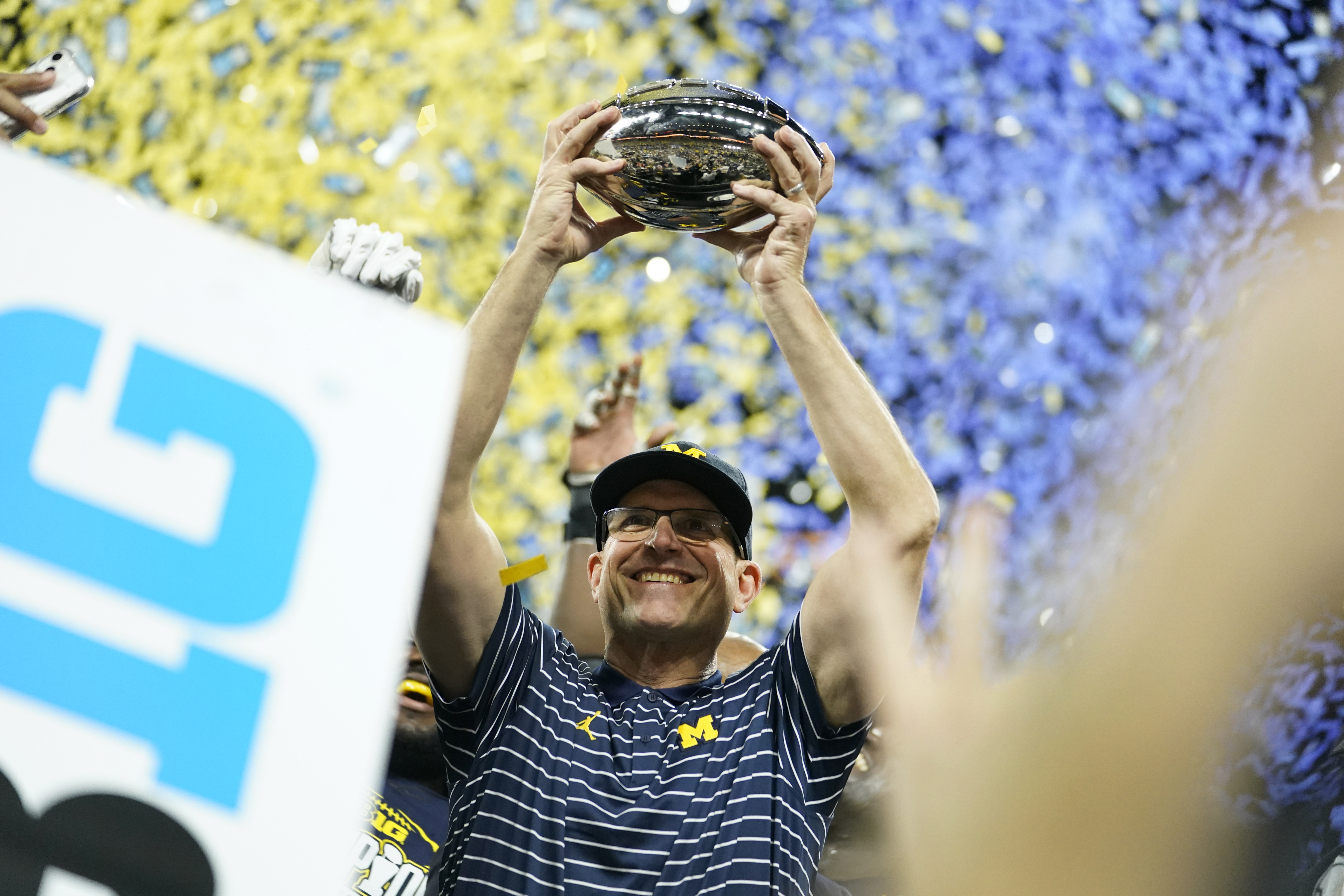 Michigan head coach Jim Harbaugh holds the trophy after defeating Purdue in the Big Ten championship NCAA college football game, early Sunday, Dec. 4, 2022, in Indianapolis. Michigan won, 43-22. (AP Photo/Michael Conroy) (Michael Conroy)