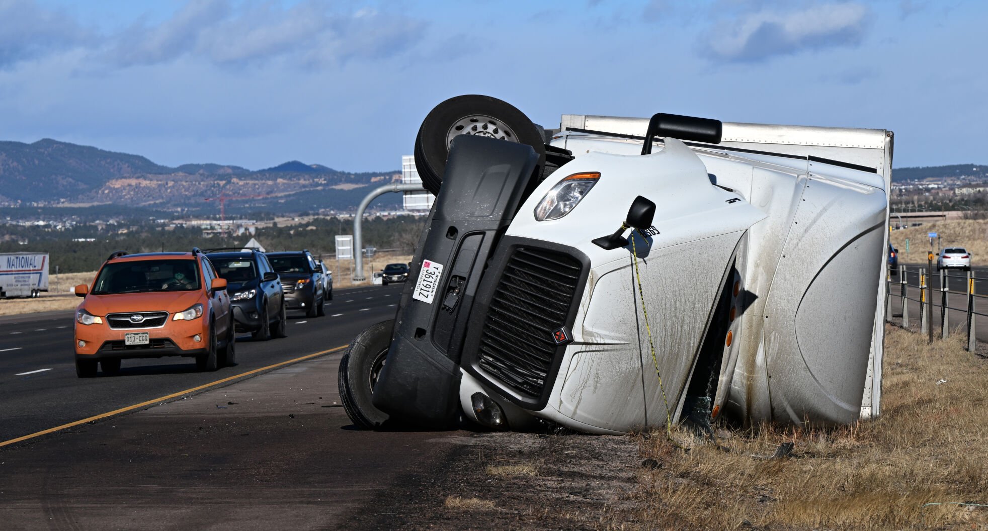 A semi truck lies on its side along the southbound lanes of Interstate 25, just south of the Interquest Parkway exit Friday morning, Dec. 2, 2022, after a storm with wind gusts up to 105 mph hit the Colorado Springs area over night. (The Gazette, Christian Murdock) (Christian Murdock/The Gazette)