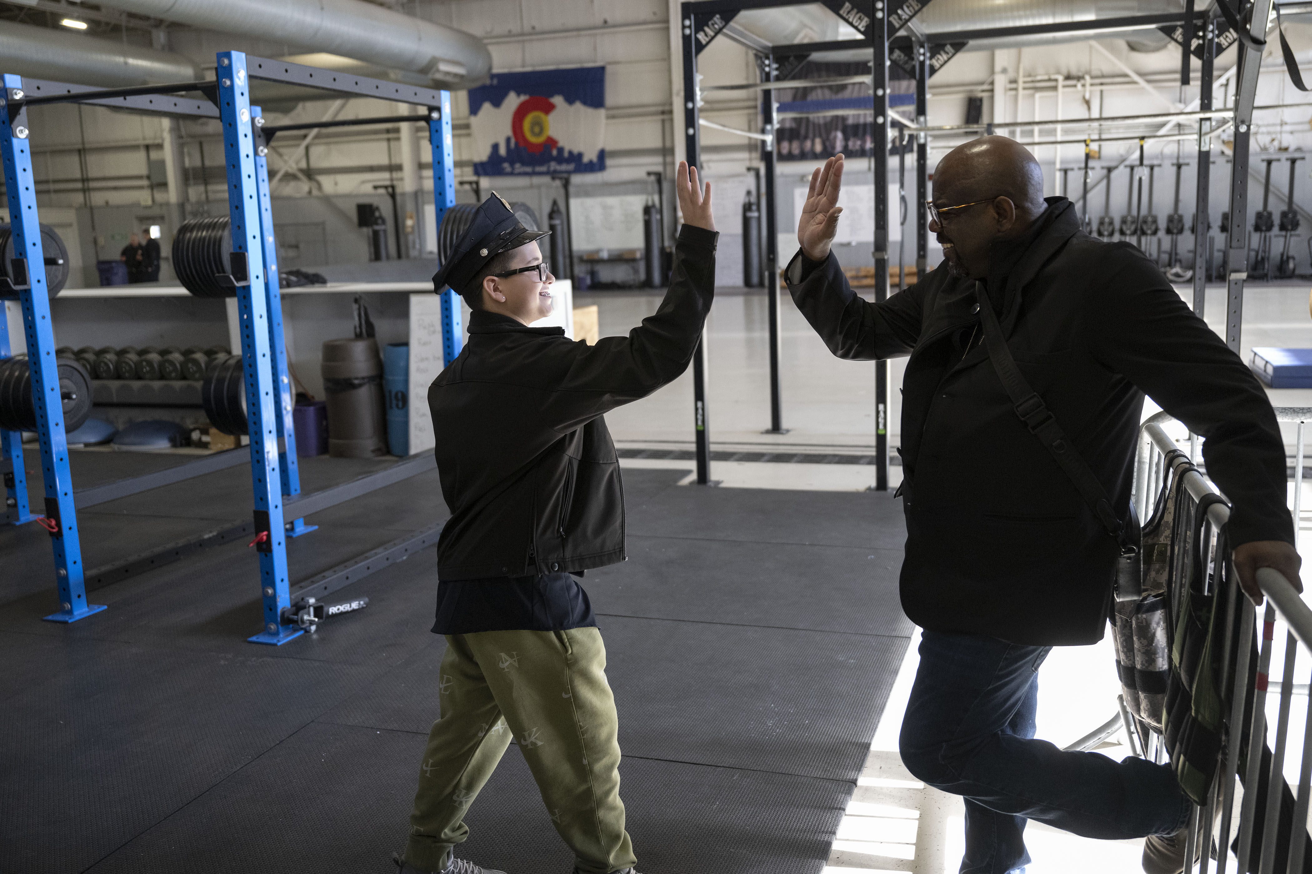 Kamorin, 14, no last name given, high-fives Denver Police technician Tyrone Campbell after a tour of the Denver Police Academy and a simulated ride along on Friday, Dec. 23, in Denver, Colo. On August 22, 2022, Kamorin was being driven home from school when a bullet fired nearby hit him in the arm. Denver police arrived and performed initial first aid. (Timothy Hurst/The Denver Gazette) (TimHursttim.hurst@gazette.comhttps://secure.gravatar.com/avatar/aca82bd62b4ee425c598527cd6faa1b1?d=mm&r=g)