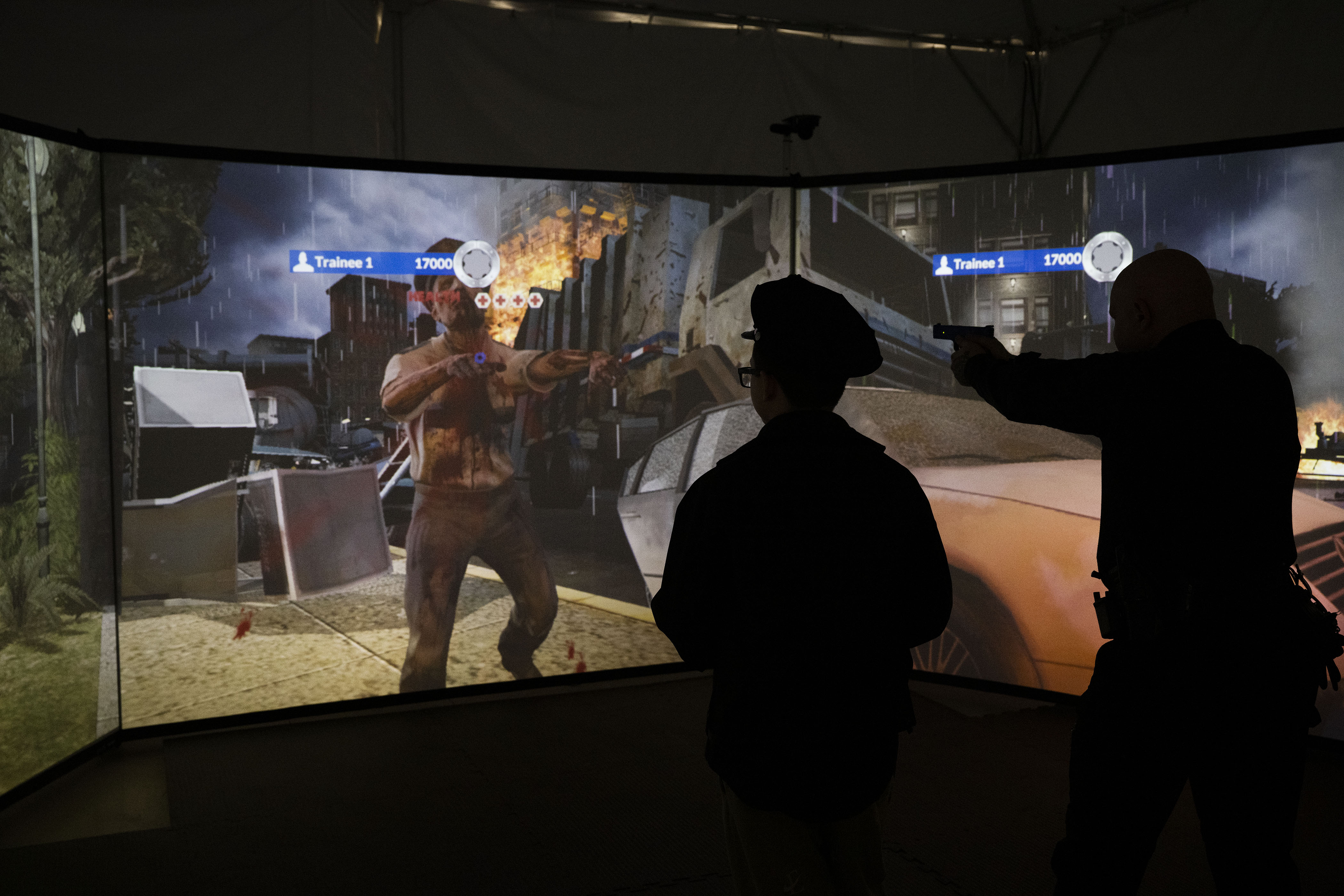 Kamorin, 14, no last name given, looks on as his partner for the day, officer David Briggs, plays a zombie game in the VirTra training simulator after a tour of the Denver Police Academy and a simulated ride along on Friday, Dec. 23, in Denver, Colo. On August 22, 2022, Kamorin was being driven home from school when a bullet fired nearby hit him in the arm. Denver police arrived and performed initial first aid. (Timothy Hurst/The Denver Gazette) (TimHursttim.hurst@gazette.comhttps://secure.gravatar.com/avatar/aca82bd62b4ee425c598527cd6faa1b1?d=mm&r=g)