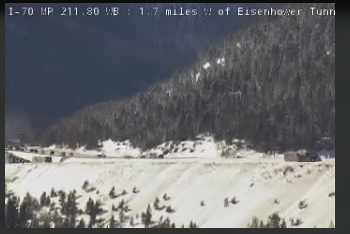 Interstate 70 in Summit County, as seen through a CDOT web camera, shows multiple vehicles stopped near the Eisenhower Tunnel, Thursday, Dec. 22, 2022. A few cars a making their way past semi-trucks however. (Screen grab, CDOT web camera)