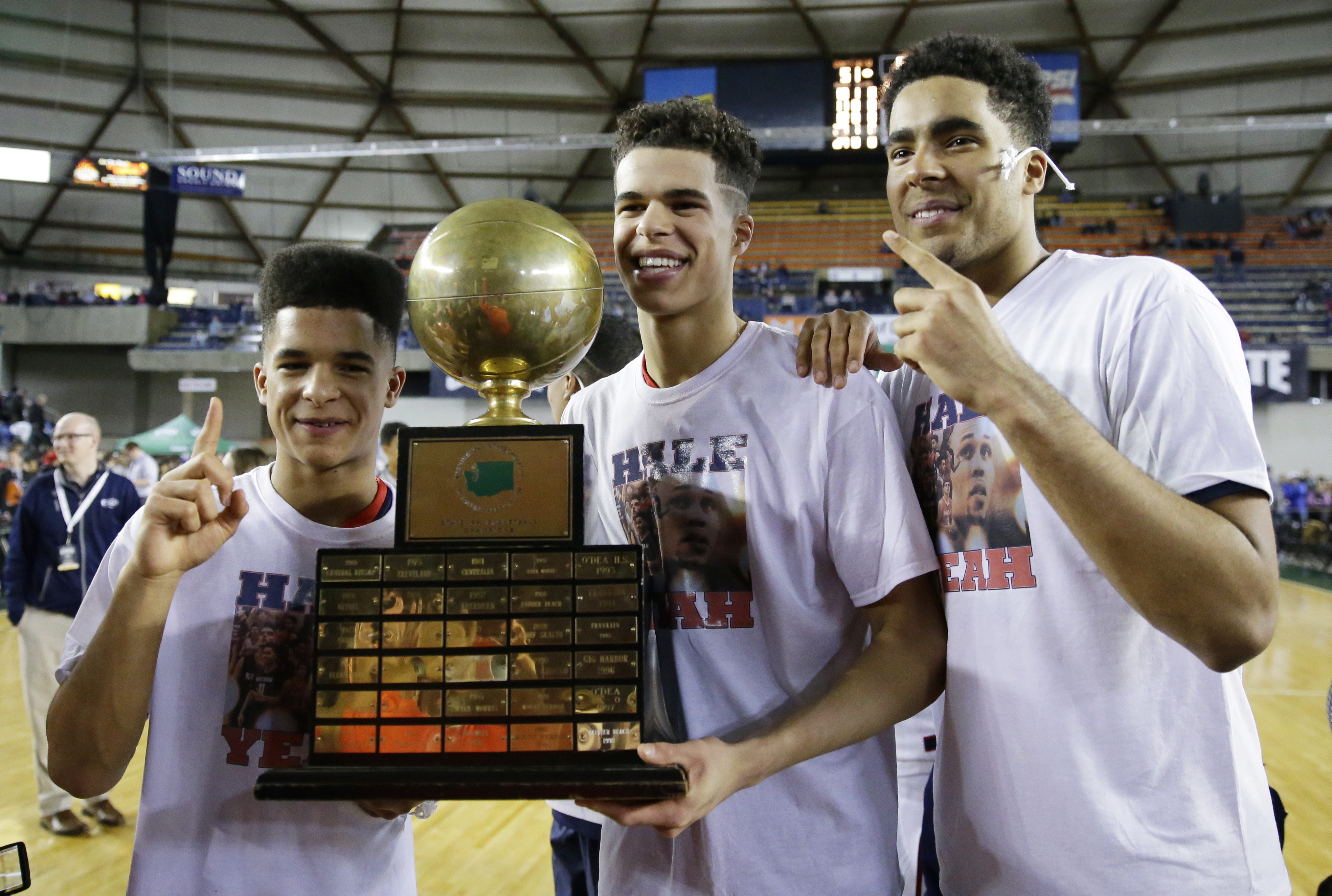 FILE - In this March 4, 2017, file photo, Nathan Hale forward Michael Porter Jr., center, poses with his brothers, Coban Porter, left, and Jontay Porter, right, while holding the trophy after Nathan Hale defeated Garfield 68-51 to win the boys' Class 3A high school basketball championship in Tacoma, Wash. Jontay Porter has announced his intention to sign with Missouri, joining his older brother and father. Porter's father, Michael Porter, Sr., was hired by first-year Missouri coach Cuonzo Martin as an assistant in March. His older brother, Michael Porter, Jr., then signed with the Tigers after initially committing to Washington. (AP Photo/Ted S. Warren, File) (Ted S. Warren)