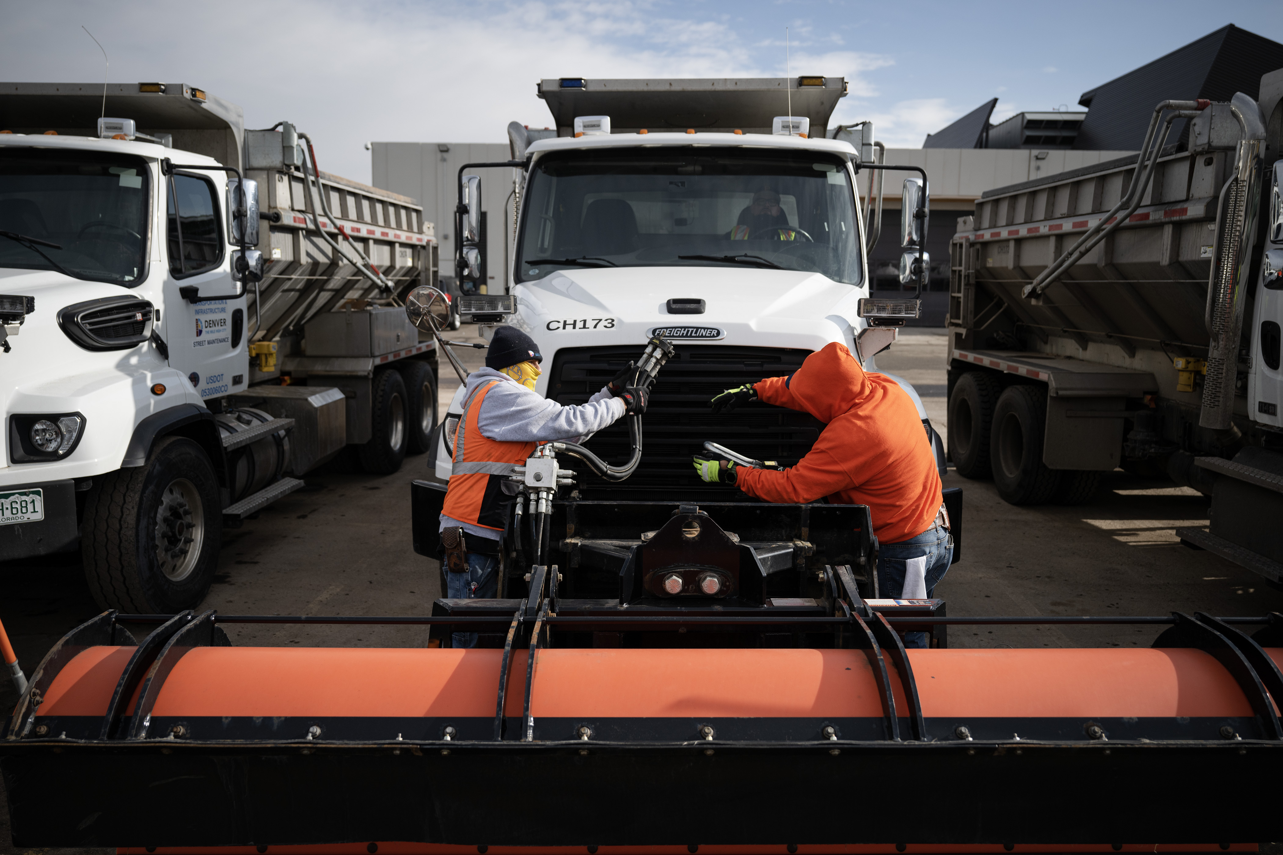 Street maintenance crew members José Carbajal hands the hydraulic lines to Polo Ramirez while demonstrating how to disconnect and reconnect a large plow on Tuesday, Jan. 17, 2023, at Denver’s Central Platte Campus in Denver, Colo.(Timothy Hurst/The Denver Gazette) (TimHursttim.hurst@gazette.comhttps://secure.gravatar.com/avatar/aca82bd62b4ee425c598527cd6faa1b1?d=mm&r=g)