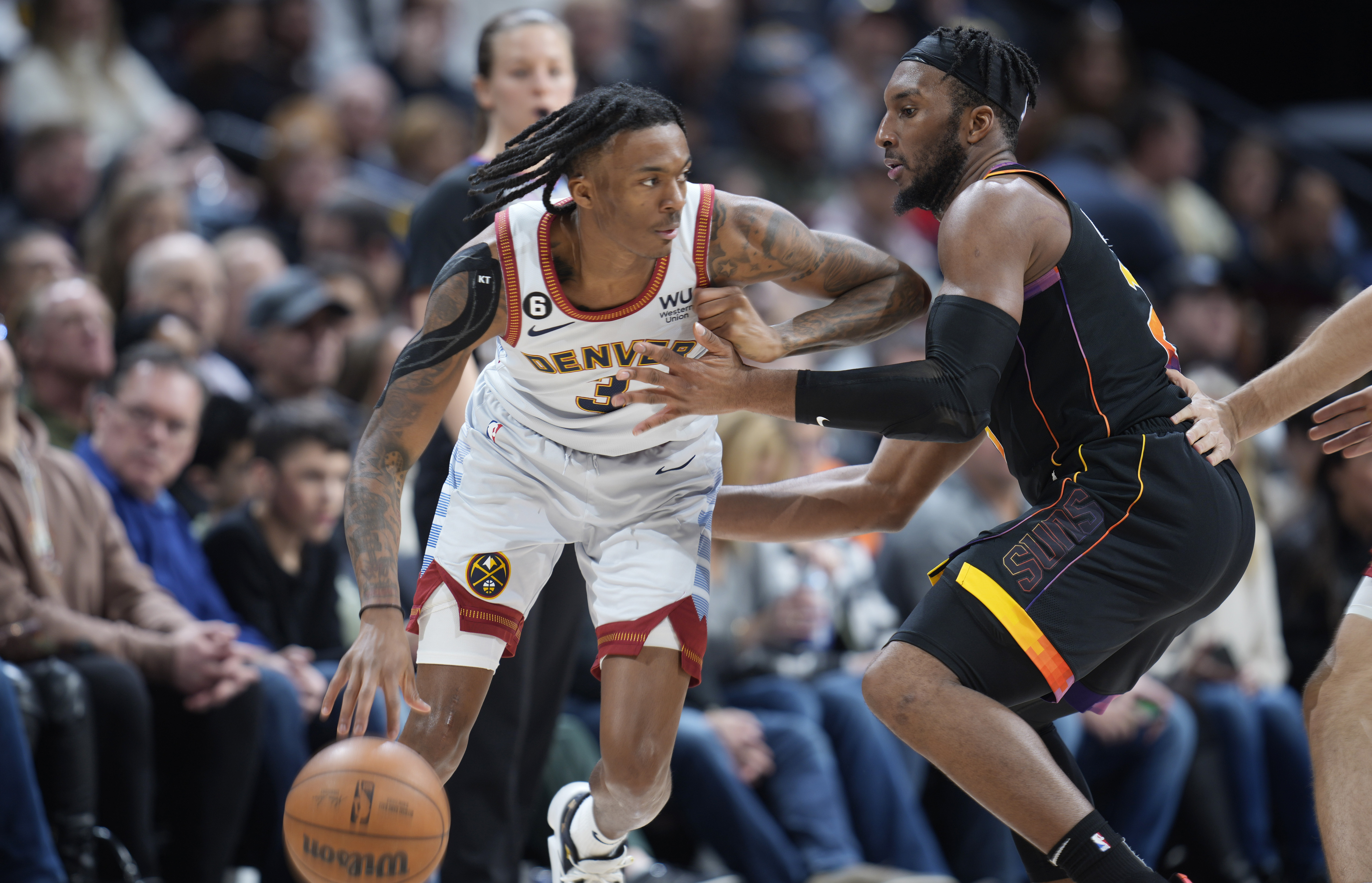 Denver Nuggets guard Bones Hyland, left, is defended by Phoenix Suns forward Josh Okogie during the second half of an NBA basketball game Wednesday, Jan. 11, 2023, in Denver. (AP Photo/David Zalubowski) (David Zalubowski)
