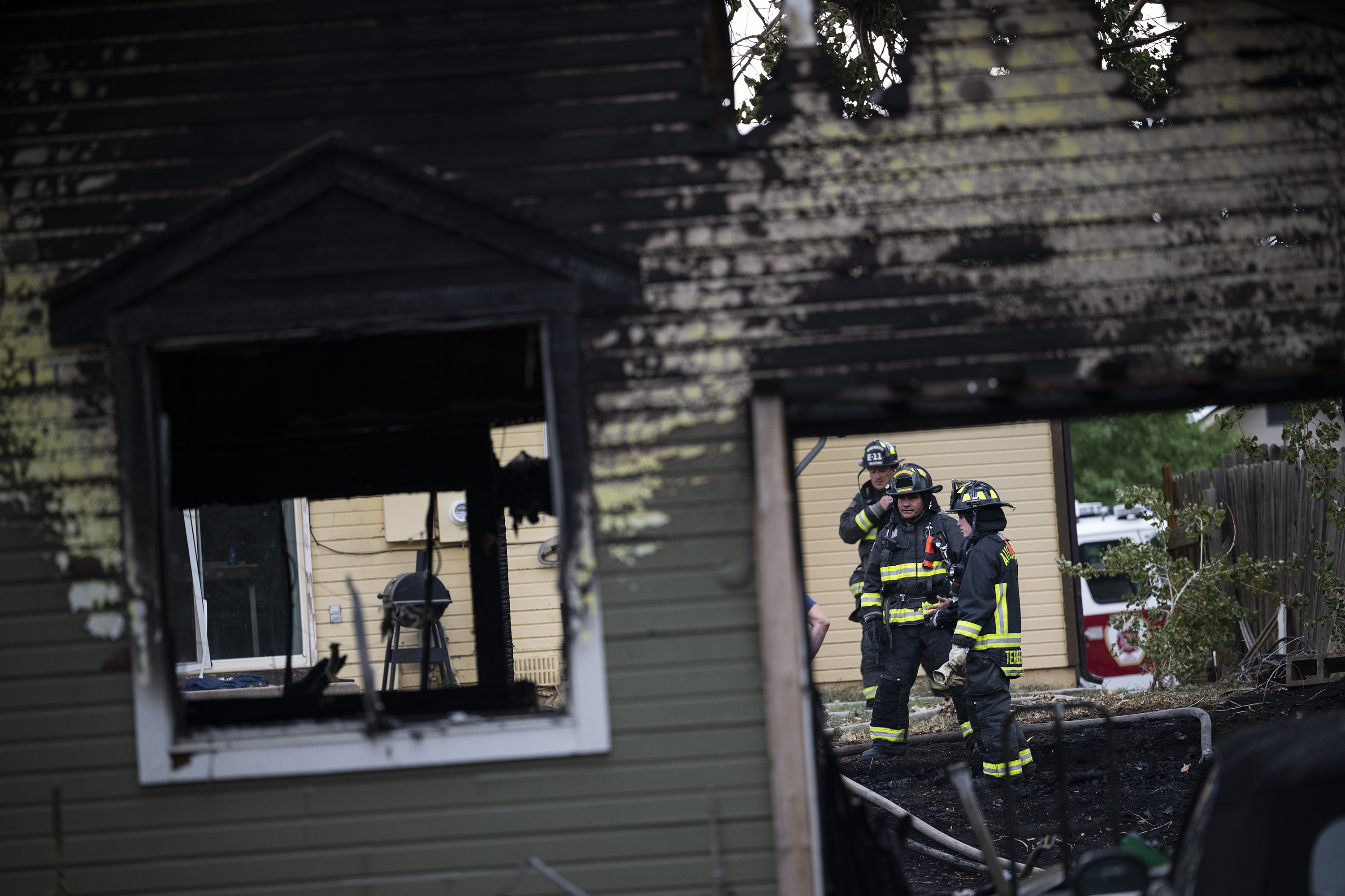 Firefighters begin cleaning up after putting out multiple house fires on the 17400 block of East Whitaker Drive on Wednesday, August 3, 2022, in Aurora, Colo. Three homes were primarily damaged, with no deaths or injuries reported, though the residents of those houses will be displaced after the damage. In total, seven engines, four ladder trucks and three battalion chiefs responded to the fires. Aurora Fire Rescue will be investigating the cause. (Timothy Hurst/The Denver Gazette) (Timothy Hurst)