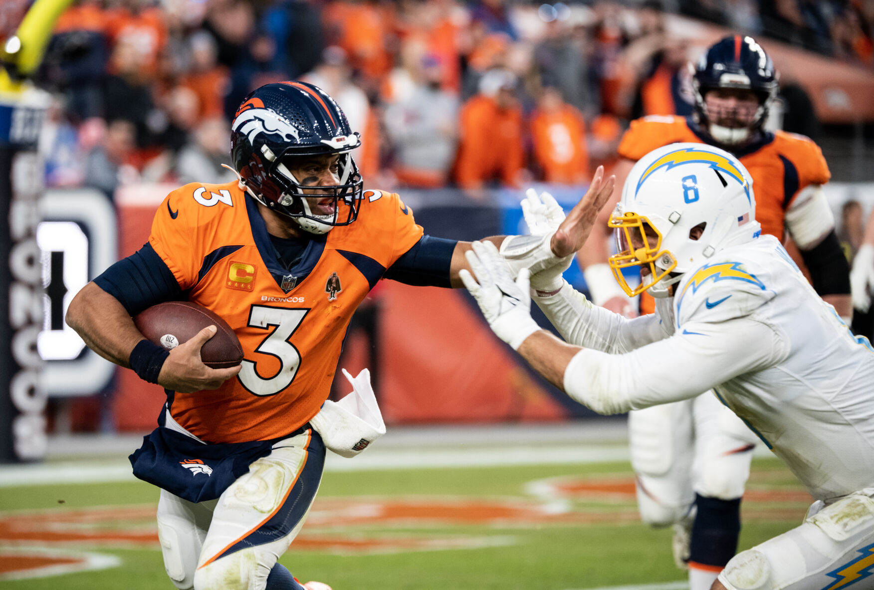 Denver Broncos quarterback Russell Wilson (3) tries to block Los Angeles Chargers Linebacker Kyle Van Noy (8) as he makes a run in the second half of the last regular season game Sunday, Jan. 8, 2023 at Empower Field at Mile High in Denver. (Parker Seibold, The Gazette) (Parker Seibold)